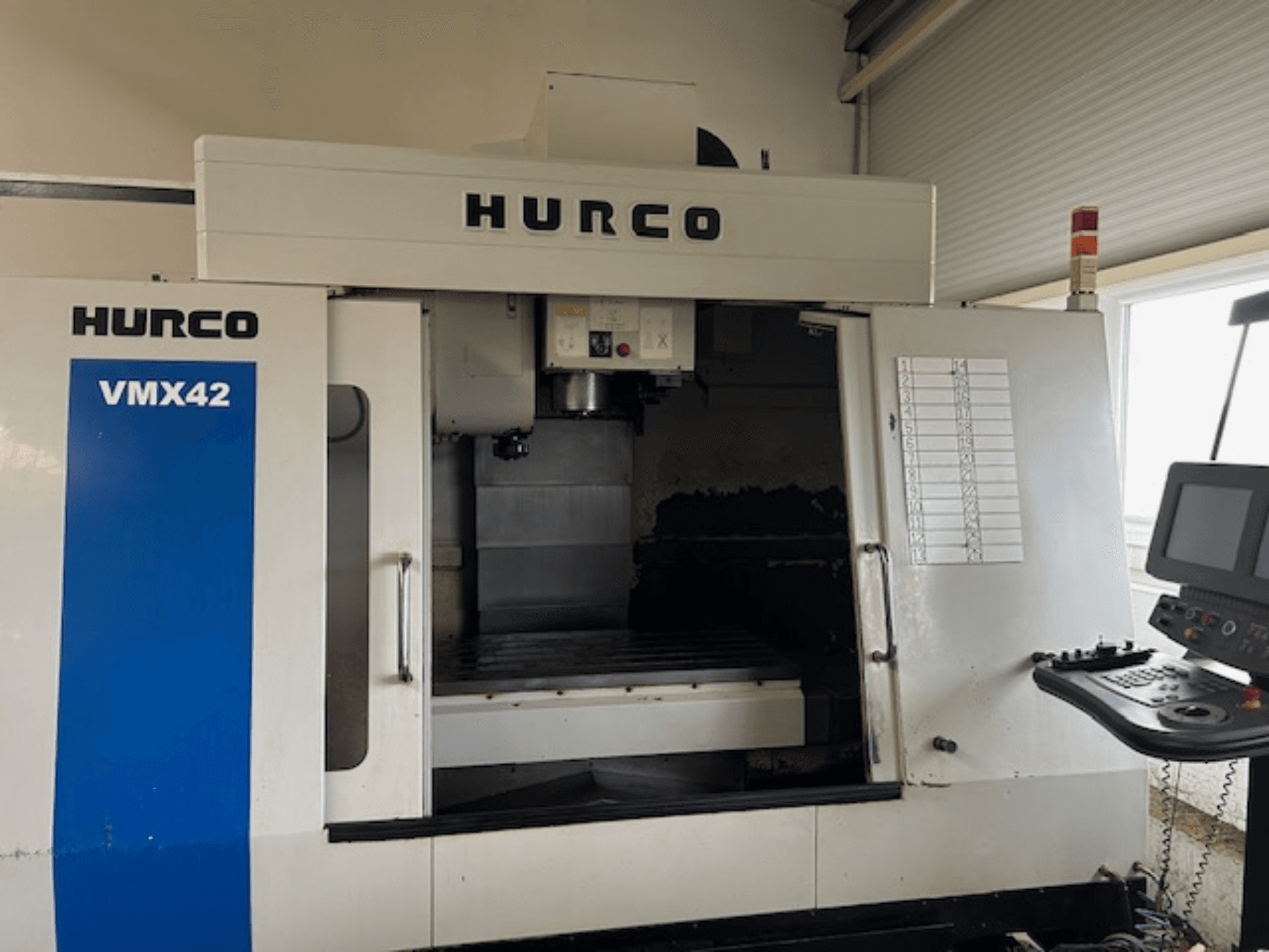 Macchina CNC Hurco VMX42 in vista frontale, che mostra il pannello di controllo, il mandrino e l'area di lavoro; rivela il layout operativo.