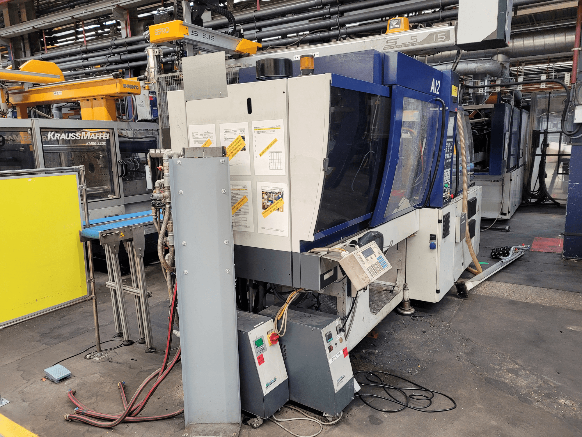 Macchina ad iniezione KraussMaffei modello KM80-232G, vista frontale, con pannello di controllo e componenti operativi.