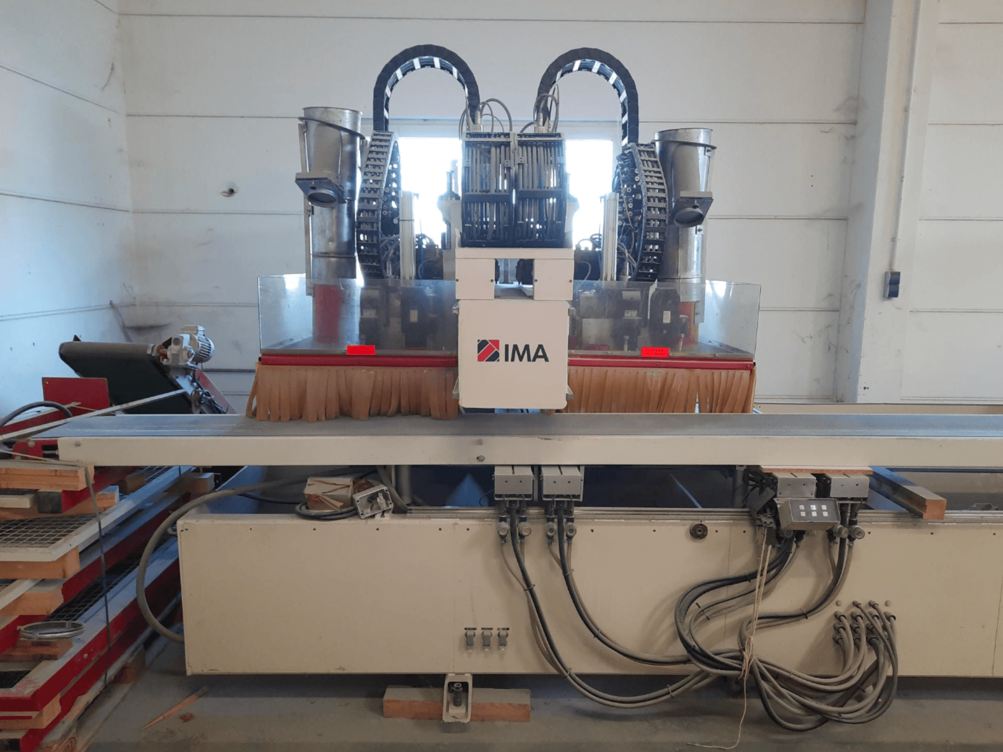 Centro di lavorazione del legno a controllo numerico IMA BIMA 610 V visto frontalmente, con spazzole, comandi e piano di lavoro.