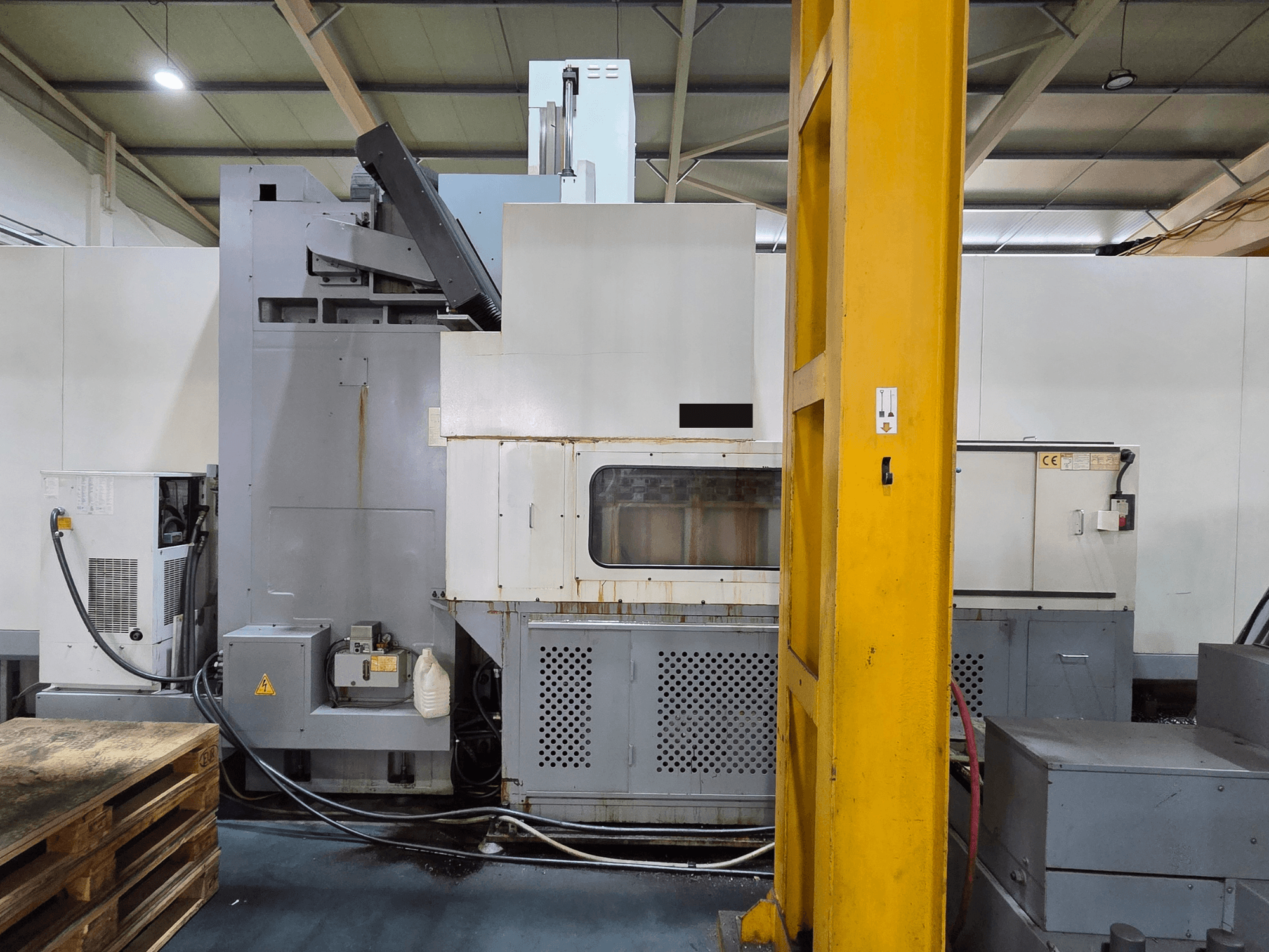 Centro di lavoro verticale HARTFORD HB 3150/S in un'officina, vista laterale che mostra il corpo macchina e i componenti collegati.