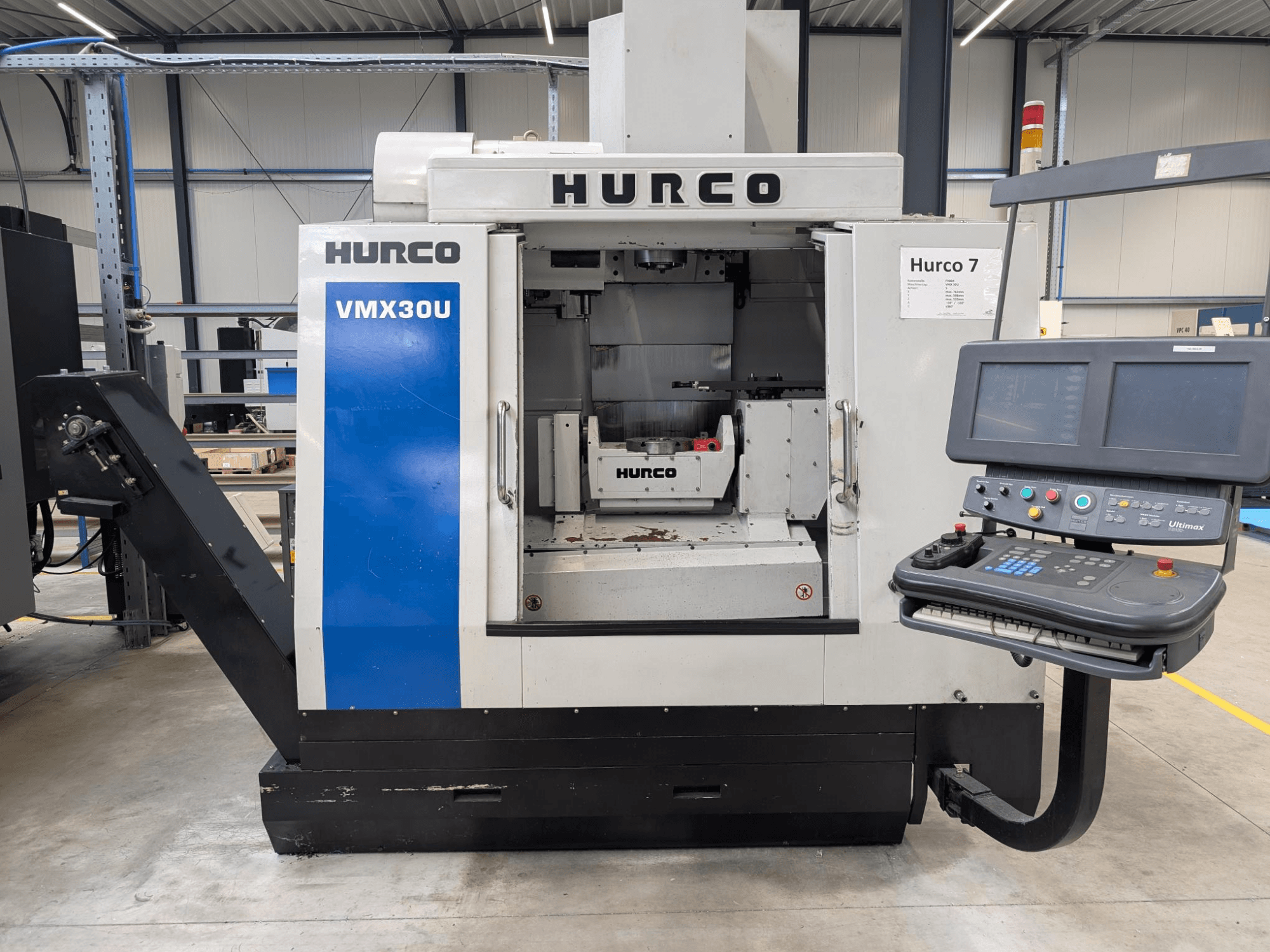 Macchina CNC Hurco VMX30U in vista frontale con pannello di controllo; presenta un interno spazioso e un'interfaccia di controllo di precisione.