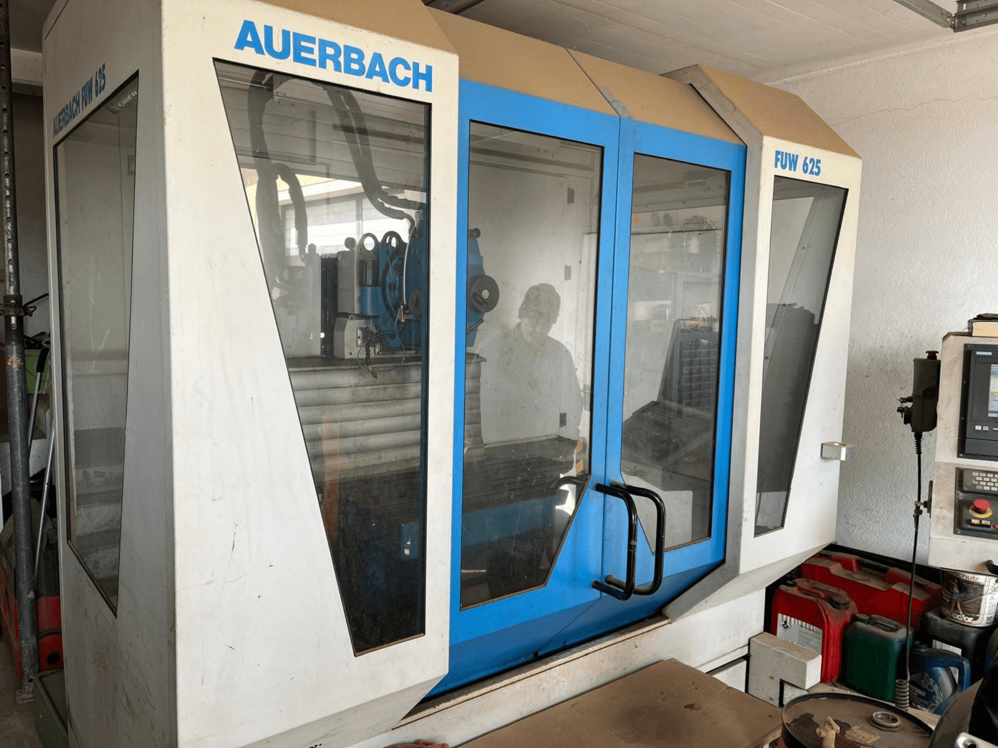 Centro di lavoro universale Auerbach FUW 625 in vista laterale, con pannelli di vetro e un pannello di controllo sulla destra.