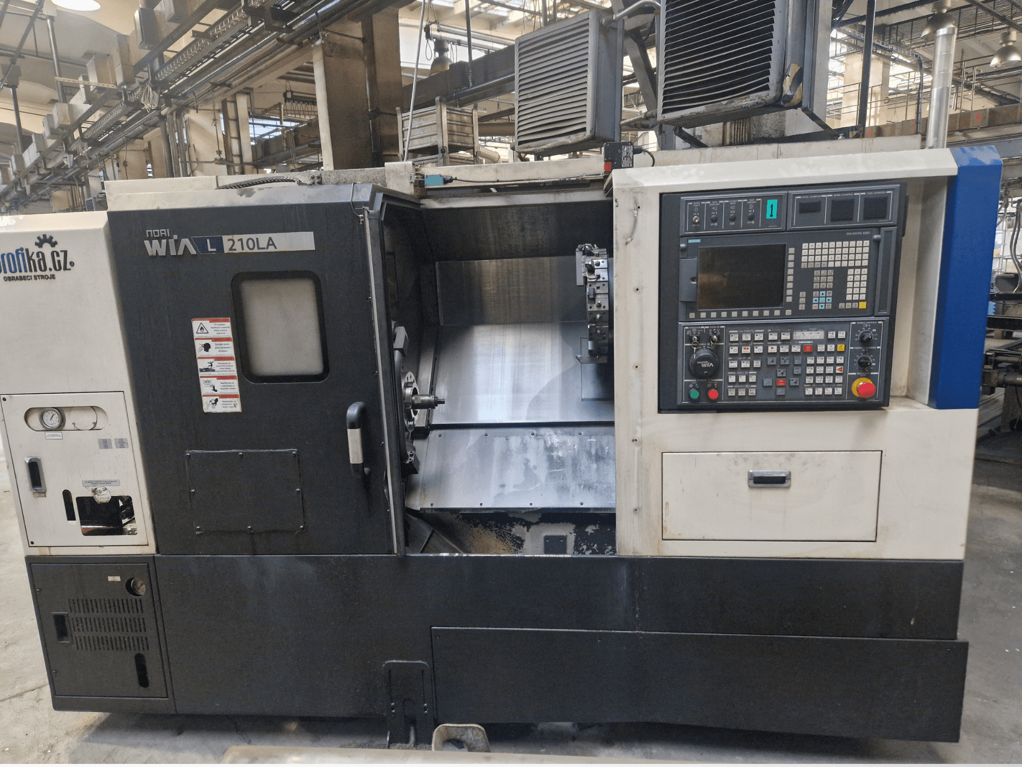 Tornio CNC WIA L210LA, vista frontale, pannello di controllo con pulsanti, display e area di lavorazione visibile.
