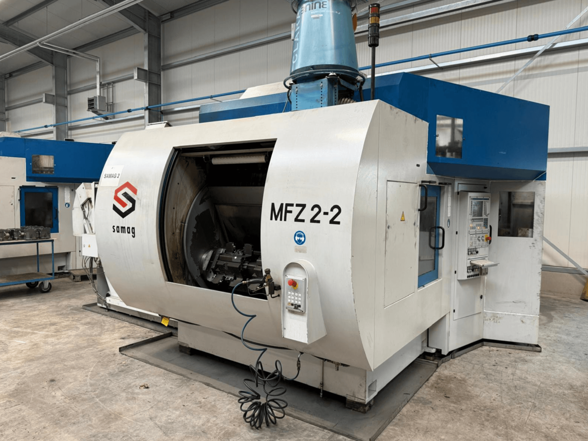 La fresatrice Samag MFZ 2-2 in vista laterale, con un'ampia camera aperta e un pannello di controllo con vari pulsanti e manopole.