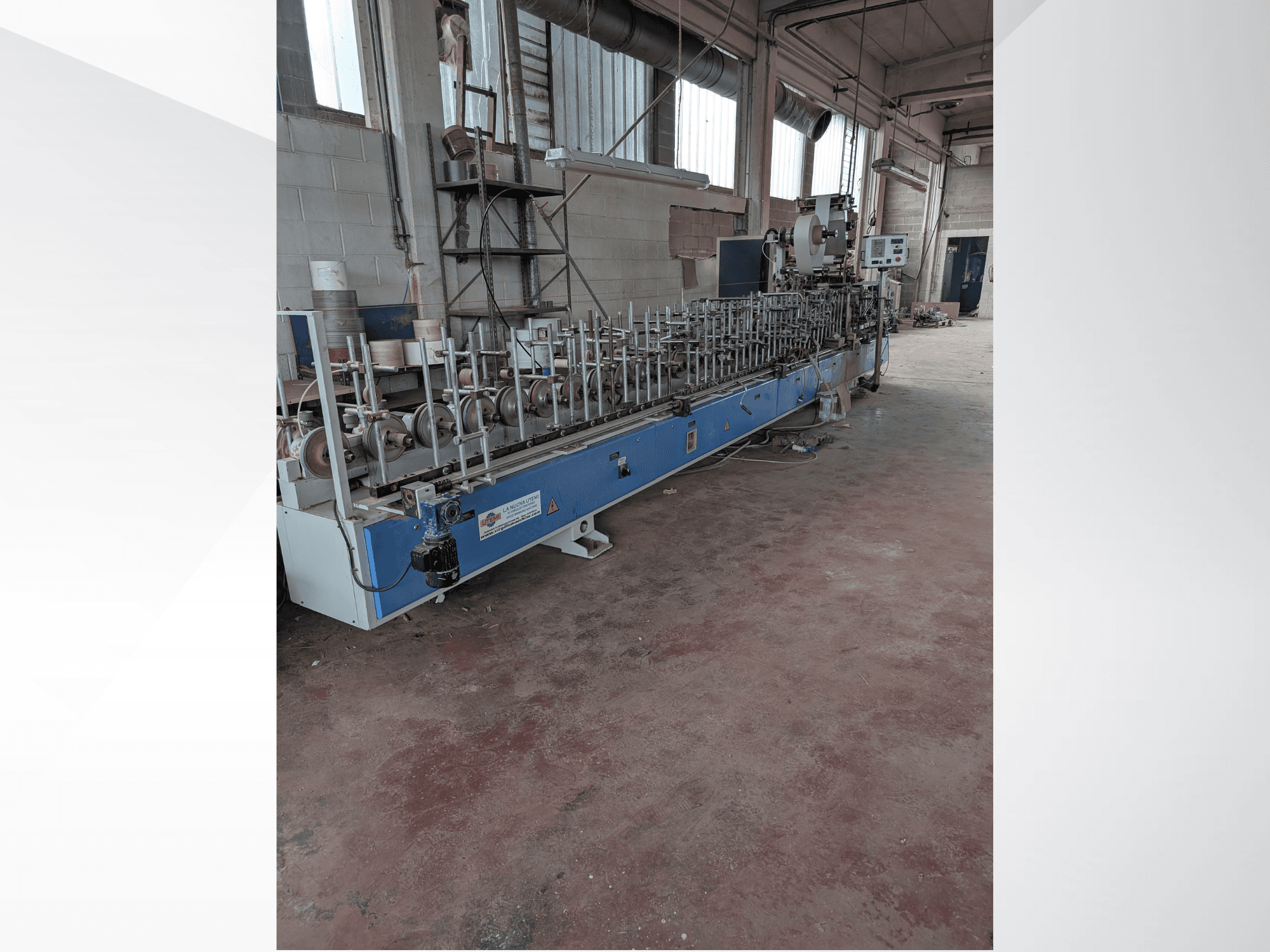 Vista frontale di una macchina PUR-33-L per il legno, caratterizzata da più mandrini e da un elegante design blu in un ambiente industriale.