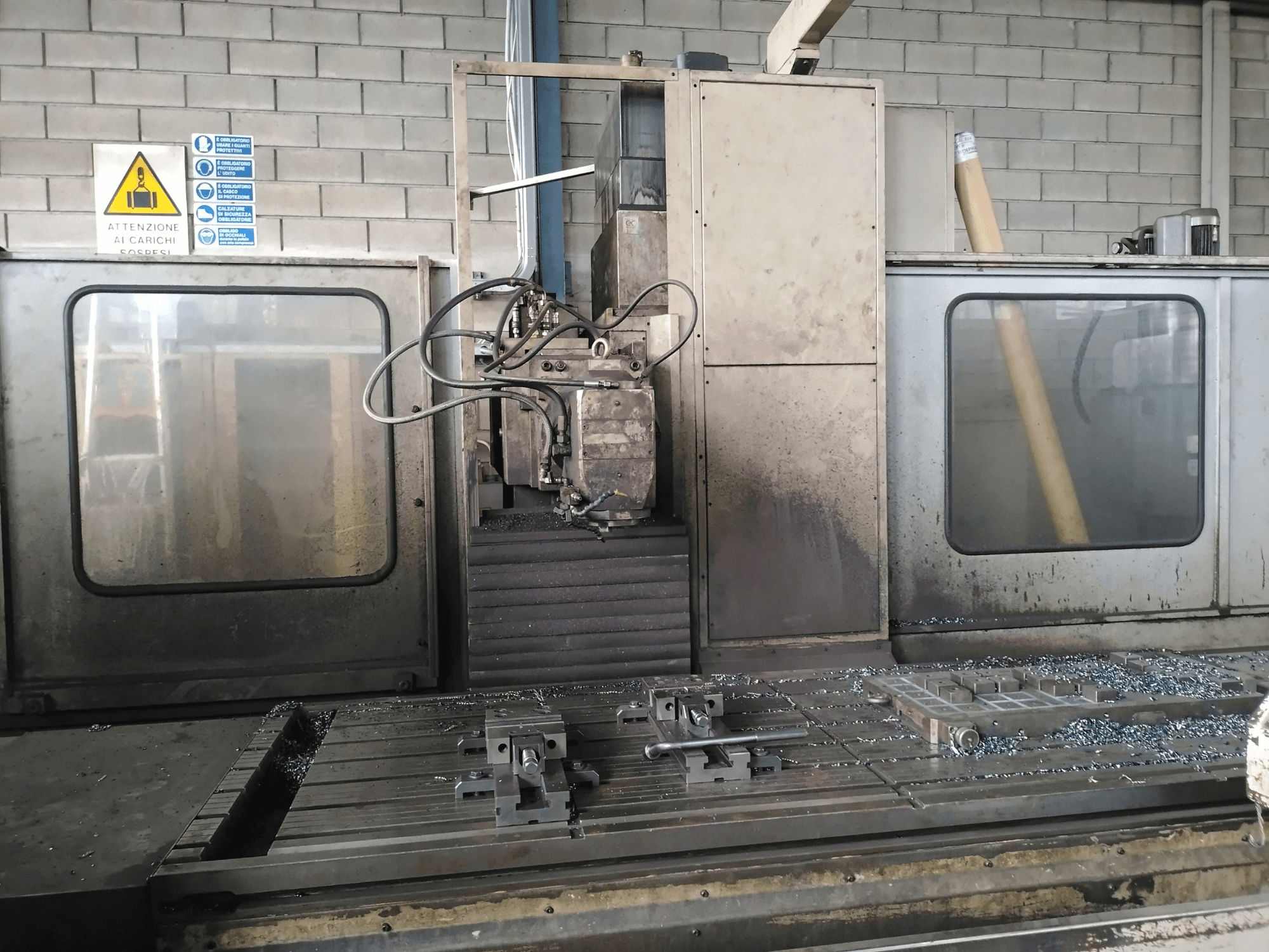 Fresatrice a banco TIGER TFA6 in un'officina, vista frontale con utensili e trucioli di metallo sul tavolo.