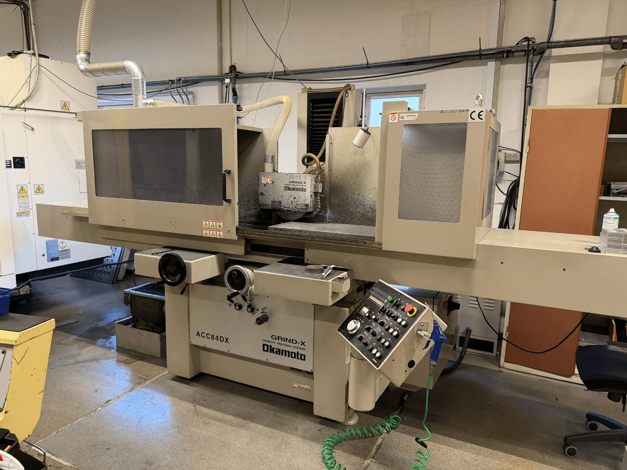 Vista frontale della rettificatrice piana OKAMOTO ACC 84DX, con pannello di comando e sistema di lubrificazione.