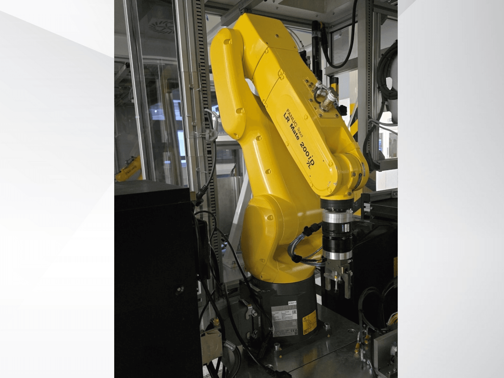 Braccio robotico Fanuc LR Mate 200iD giallo visto di lato, con pinza e vari cavi collegati.