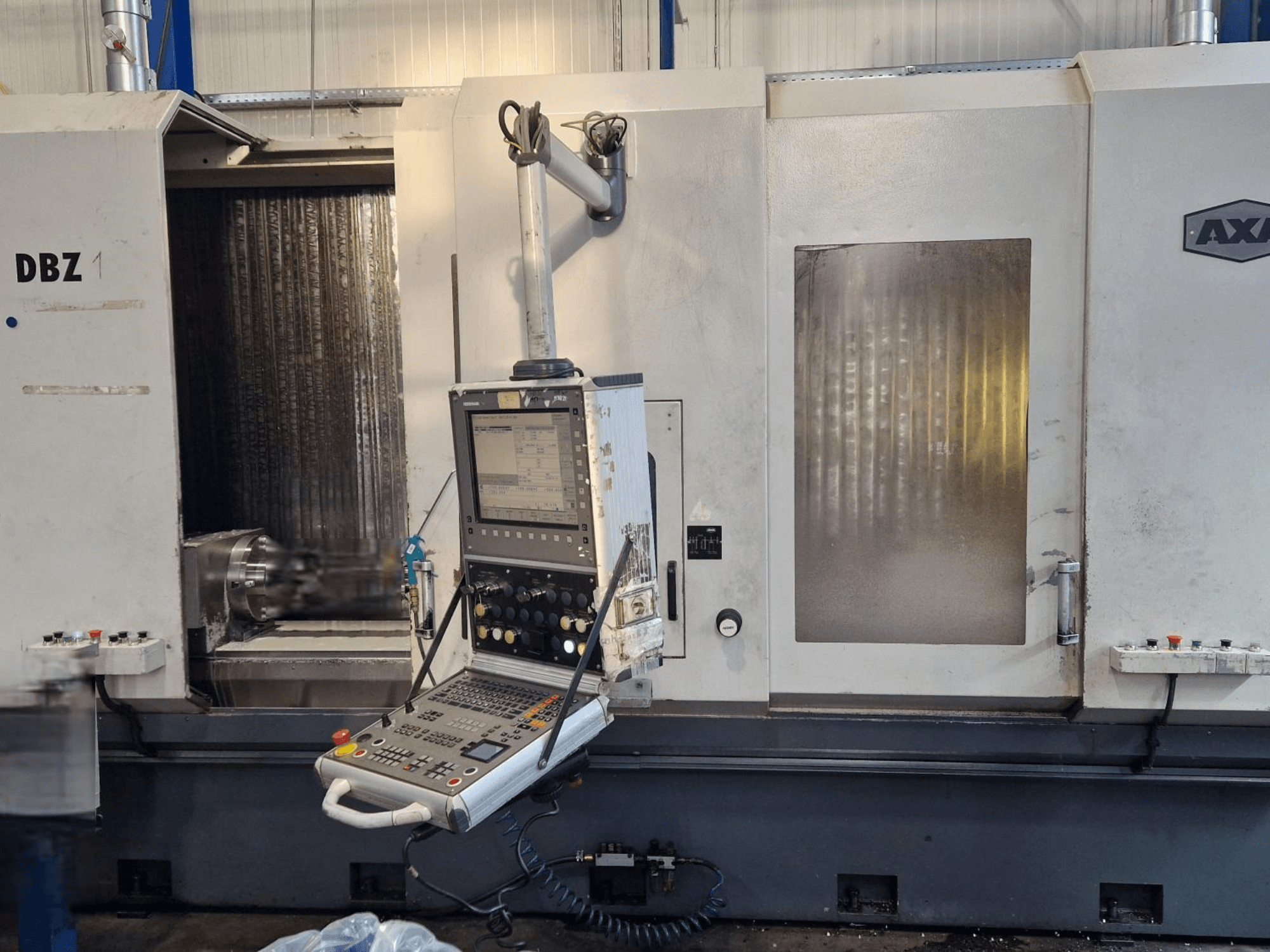Centro di lavoro verticale AXA DBZ visto da una vista frontale angolata, con pannello di controllo e area utensili da taglio visibile.
