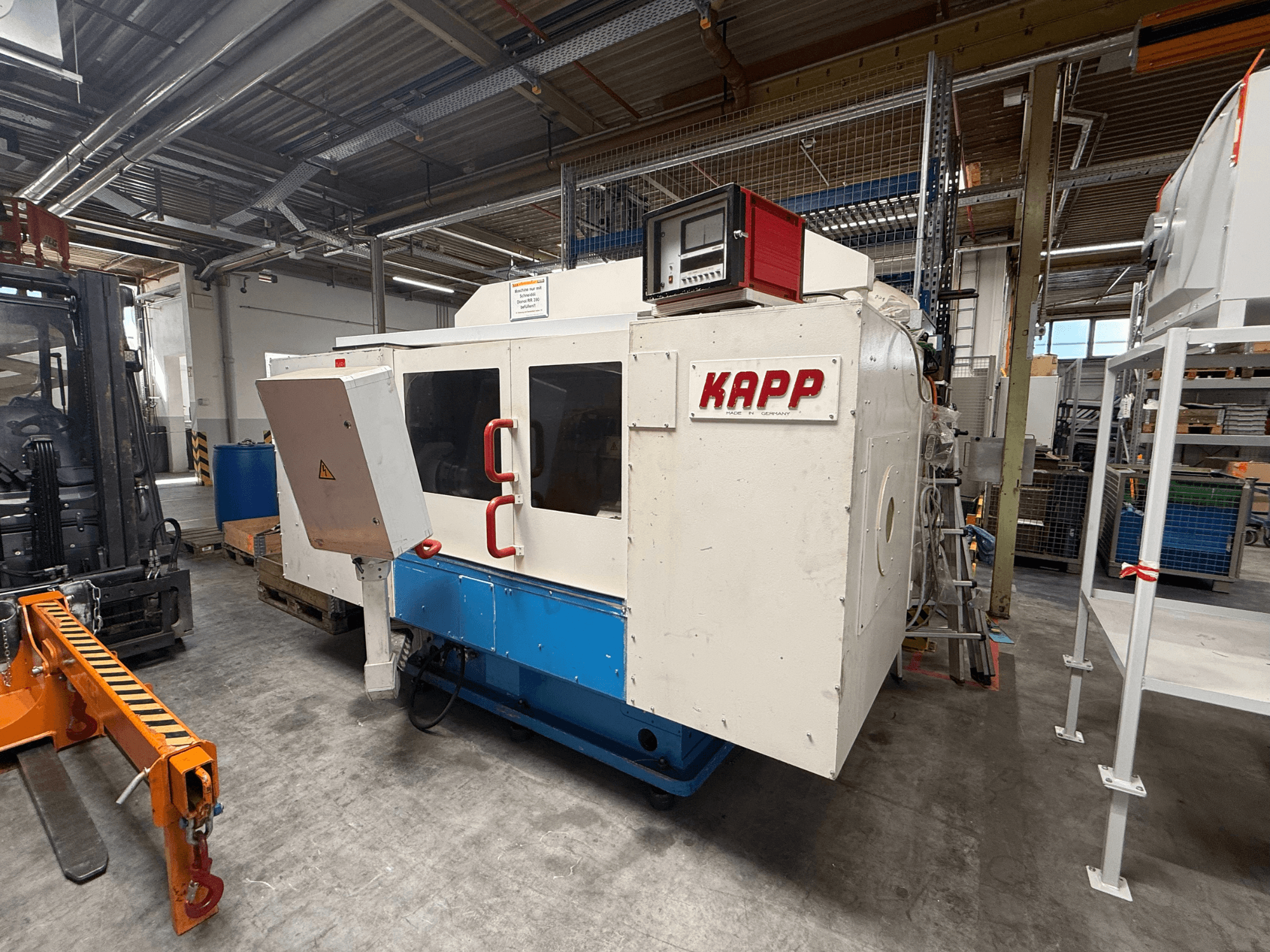 Rettificatrice cilindrica KAPP RNS 55 vista di profilo, con pannello di comando e cabina di sicurezza in un ambiente di officina.