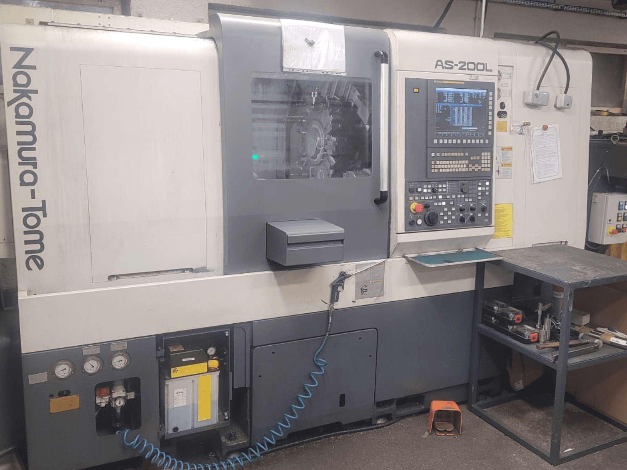 Tornio orizzontale NAKAMURA-TOME AS-200L, vista frontale con pannello di controllo, mandrino e caratteristiche della macchina.