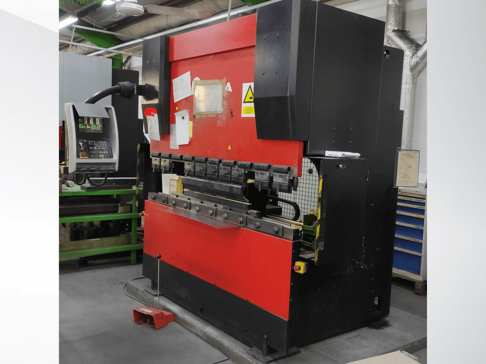 Pressa piegatrice AMADA HFB 5020 in rosso e nero, vista frontale, con pannello di controllo, utensili di piegatura e caratteristiche di sicurezza.