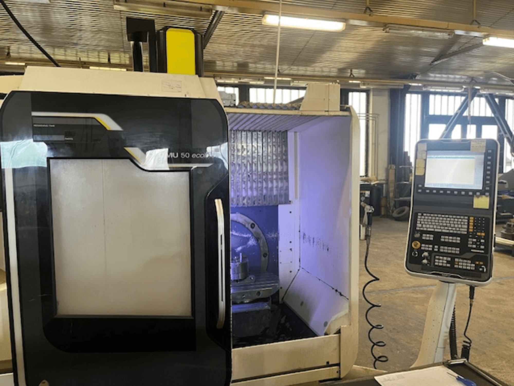 Vista frontale della fresatrice DMU 50 eco con pannello di controllo, visualizzazione del portautensili e dell'area di lavoro.