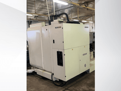 Macchina industriale CNC bianca vista frontalmente, con pannello di controllo e ventilazione, in un'officina.