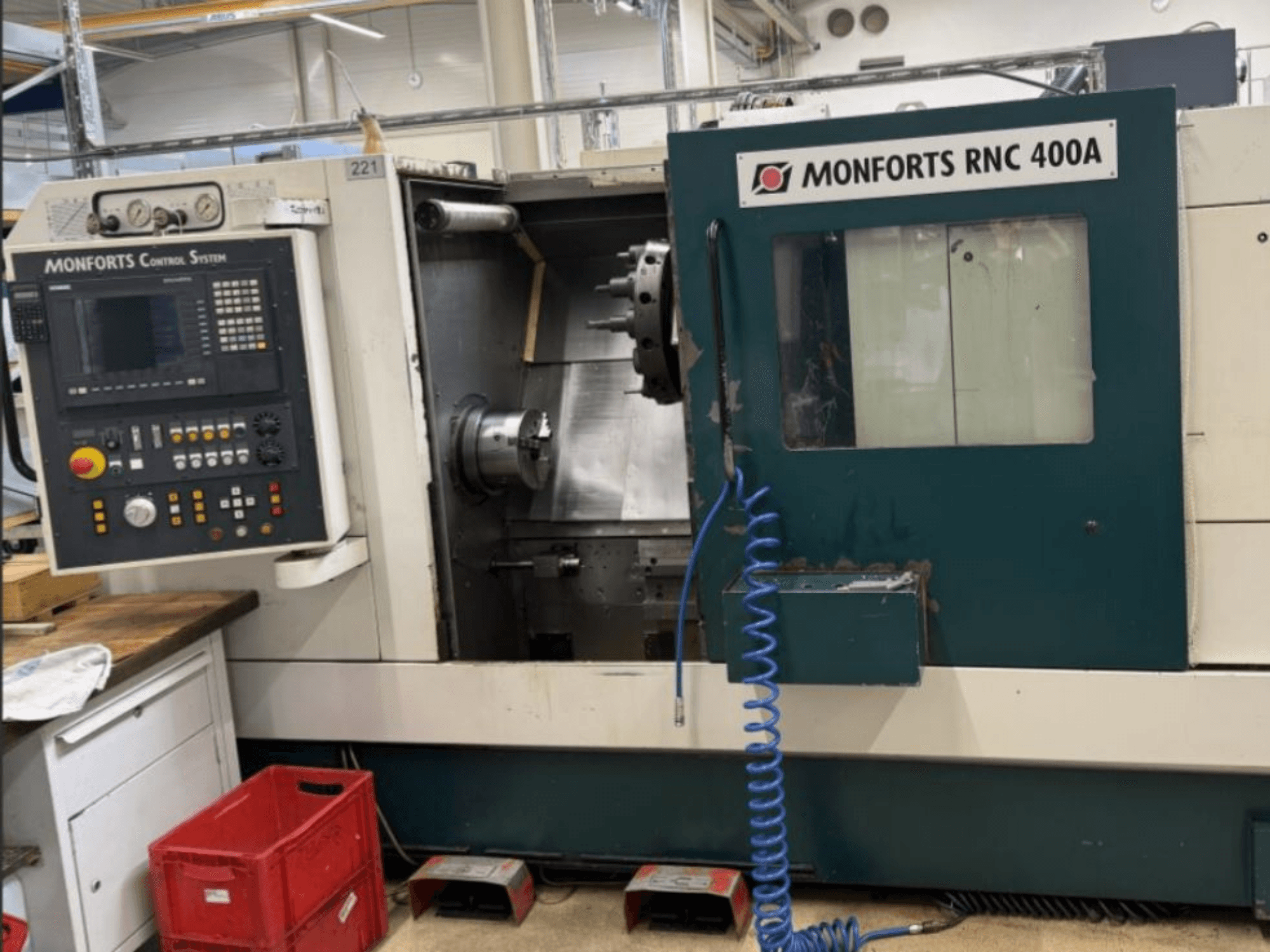 Tornio orizzontale Monforts RNC 400 A, vista frontale, che mostra il pannello di controllo e l'area di lavoro con le caratteristiche evidenziate.