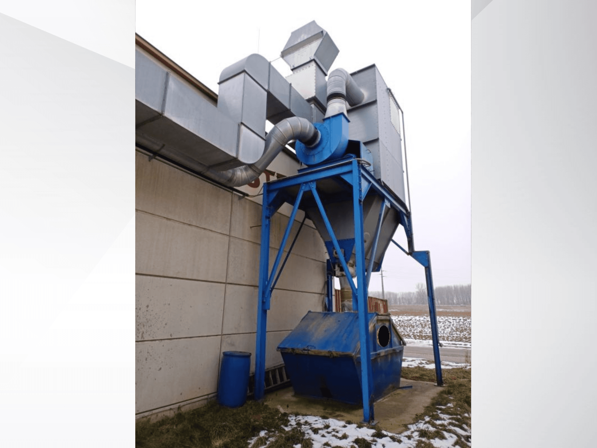 Sistema di aspirazione LBH in blu con separatore cilindrico e tubi di collegamento, vista frontale su sfondo innevato.