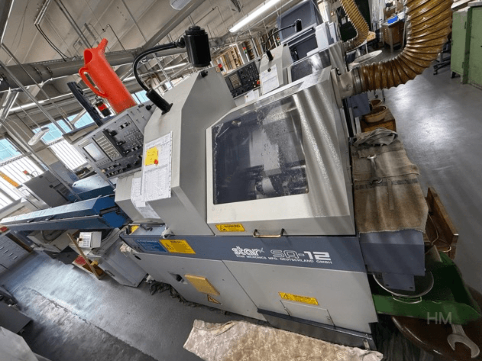 Centro di lavoro Star SQ-12, vista laterale con pannello di controllo, contenitore del refrigerante e tubo di aspirazione della polvere visibili.