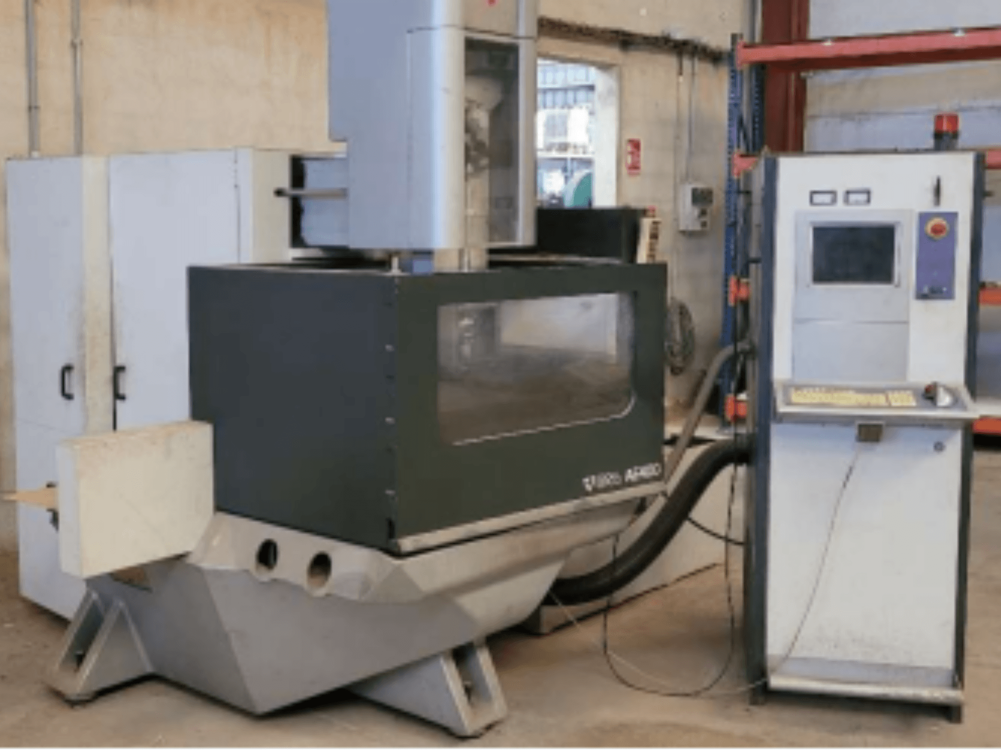 Macchina per elettroerosione a filo ONA AE 400 in un'officina, con un pannello di controllo sulla destra e un'ampia area di taglio.