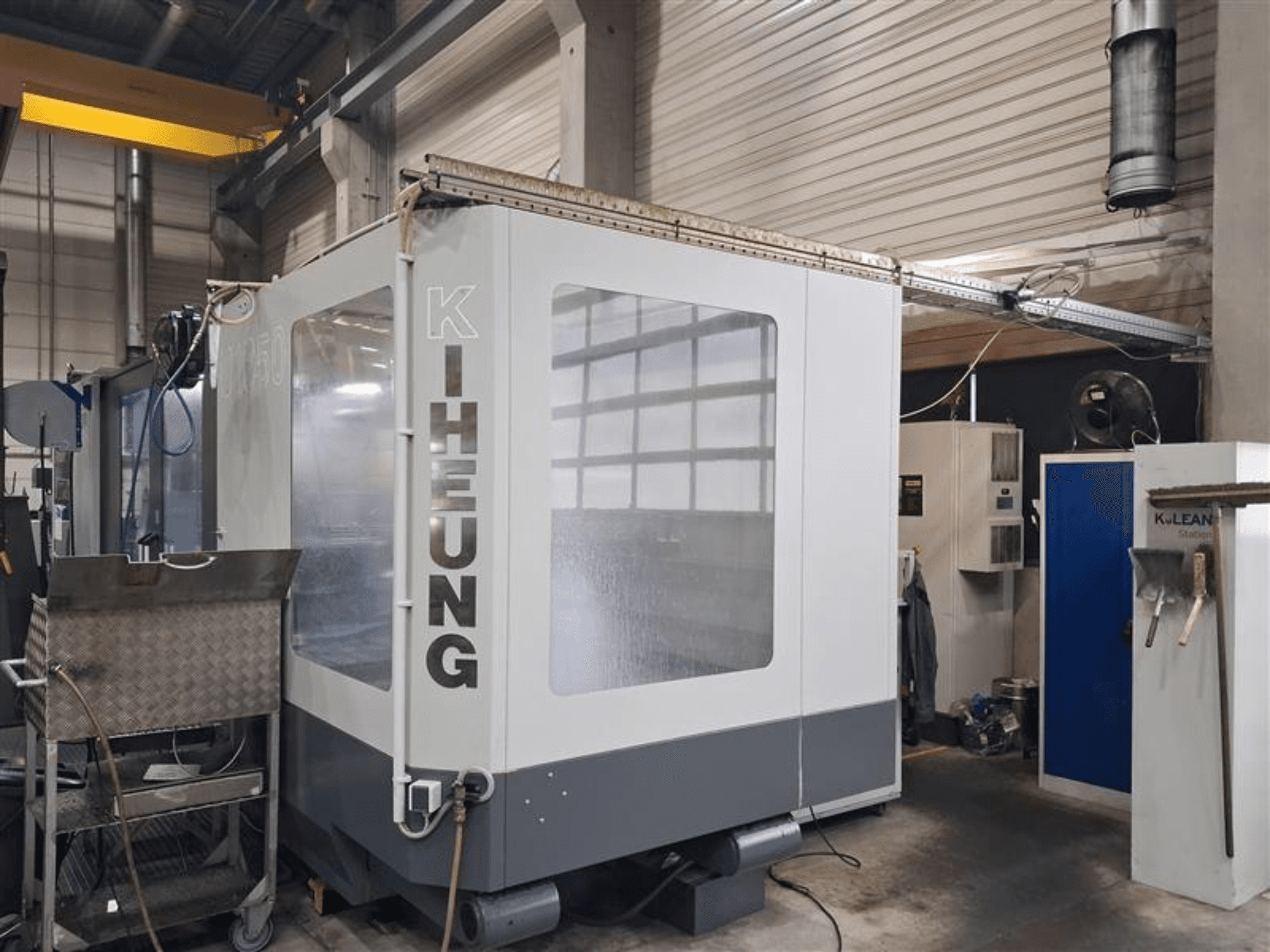 Fresatrice a bancale KIHEUNG Volmatec KNC U1050, vista frontale che mostra l'involucro metallico e l'unità di controllo sullo sfondo.