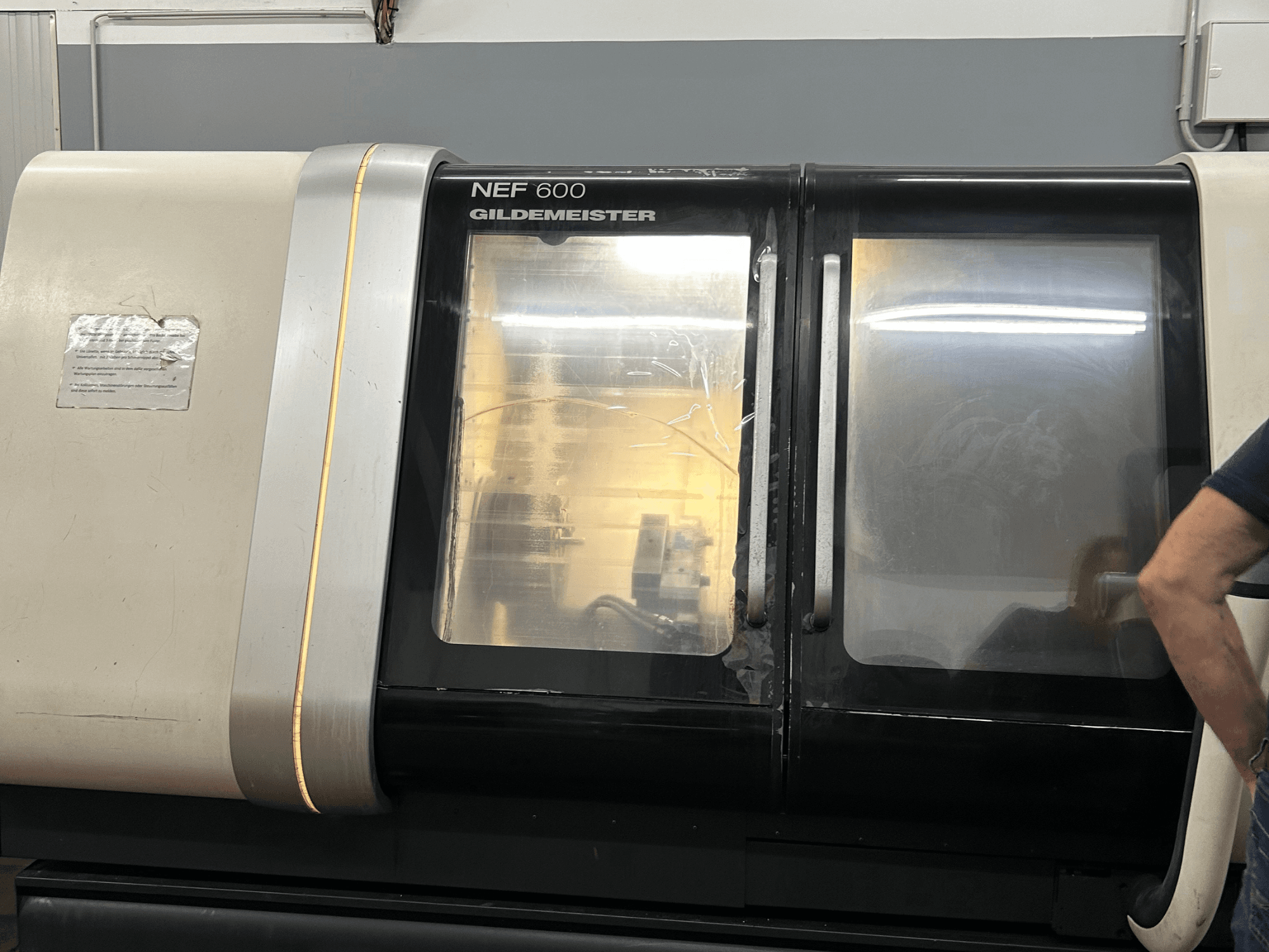 Tornio orizzontale DMG NEF 600, vista frontale, con finitura lucida e ampie finestre di visualizzazione.
