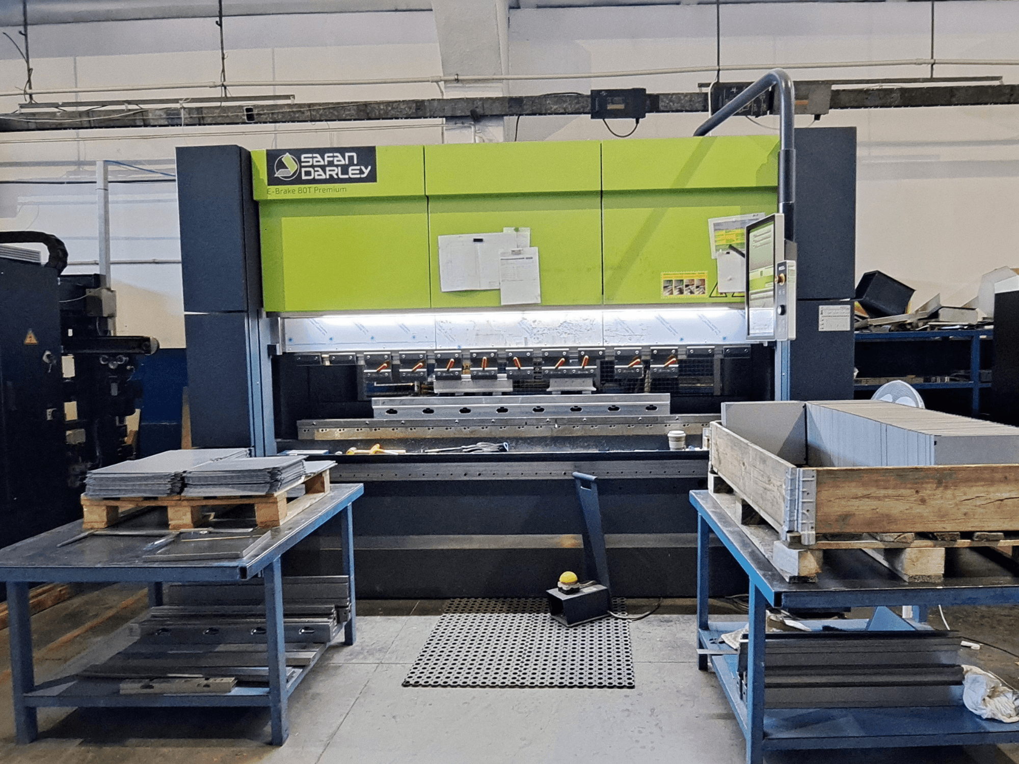 Piegatrice SAFAN E-Brake Premium 80-2550 in un'officina, vista frontale con lamiere impilate e pannello di controllo visibile.