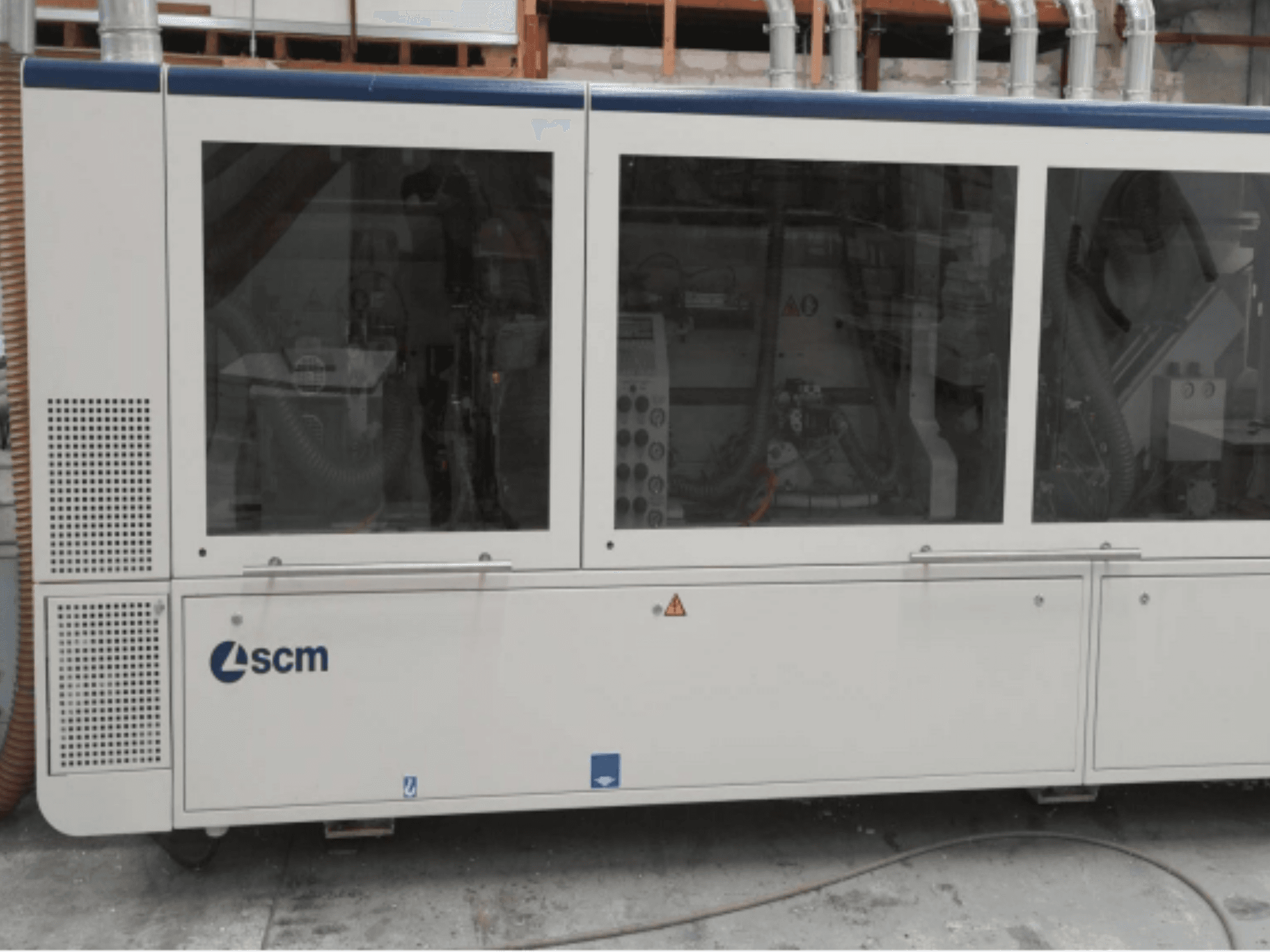 Macchina industriale SCM, vista laterale, caratterizzata da pannelli trasparenti e prese d'aria visibili; progettata per l'efficienza dei processi produttivi.
