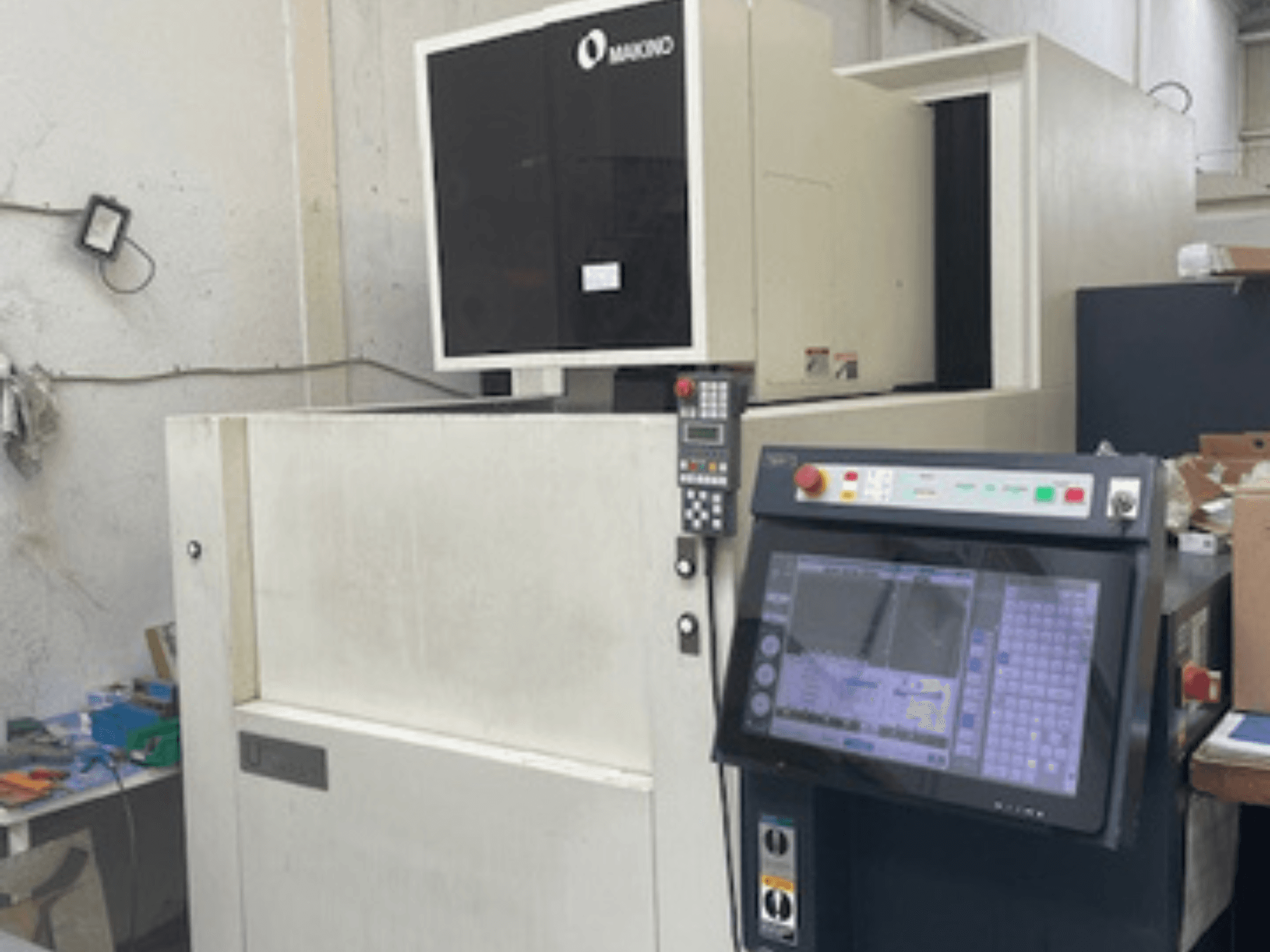 Macchina per elettroerosione a filo Makino U6 HEAT in un'officina, vista frontale che mostra il pannello di controllo e il display digitale.