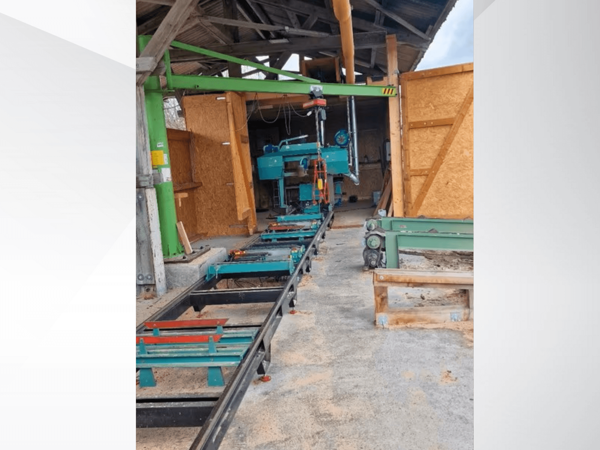 Segatrice a nastro orizzontale in officina, vista dal davanti. L'attrezzatura comprende un binario e altri accessori verdi.