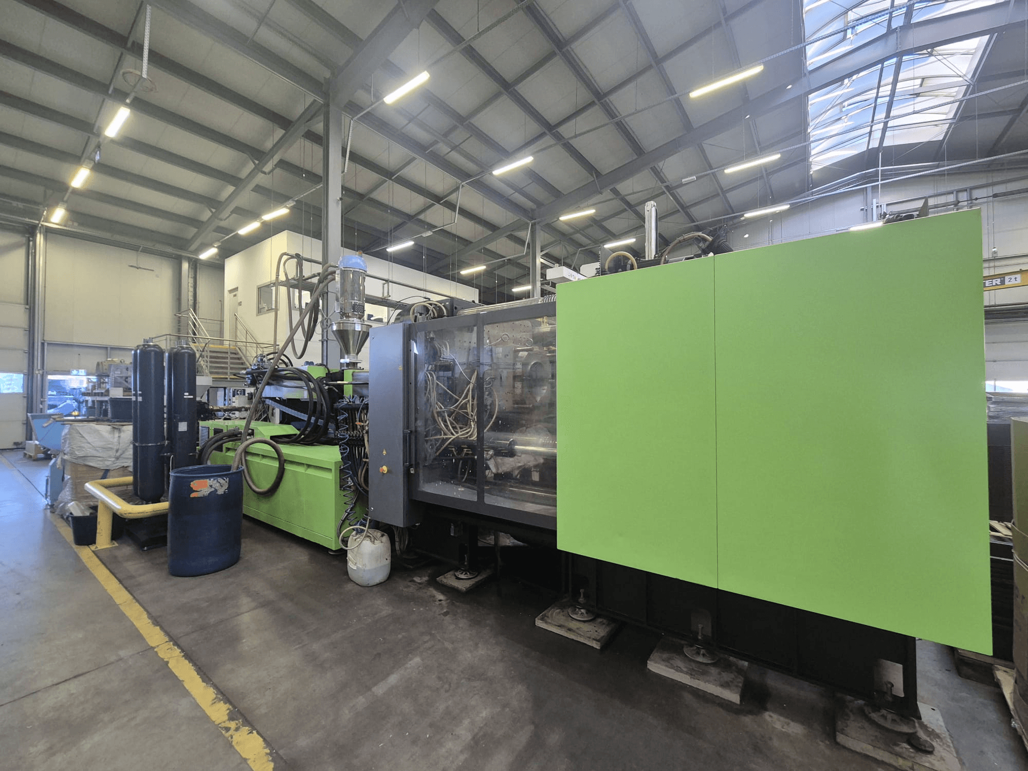 Macchina per lo stampaggio a iniezione idraulica Engel duo 5160/700 in un ambiente industriale, vista di lato, che ne mette in risalto la carrozzeria verde e i componenti.