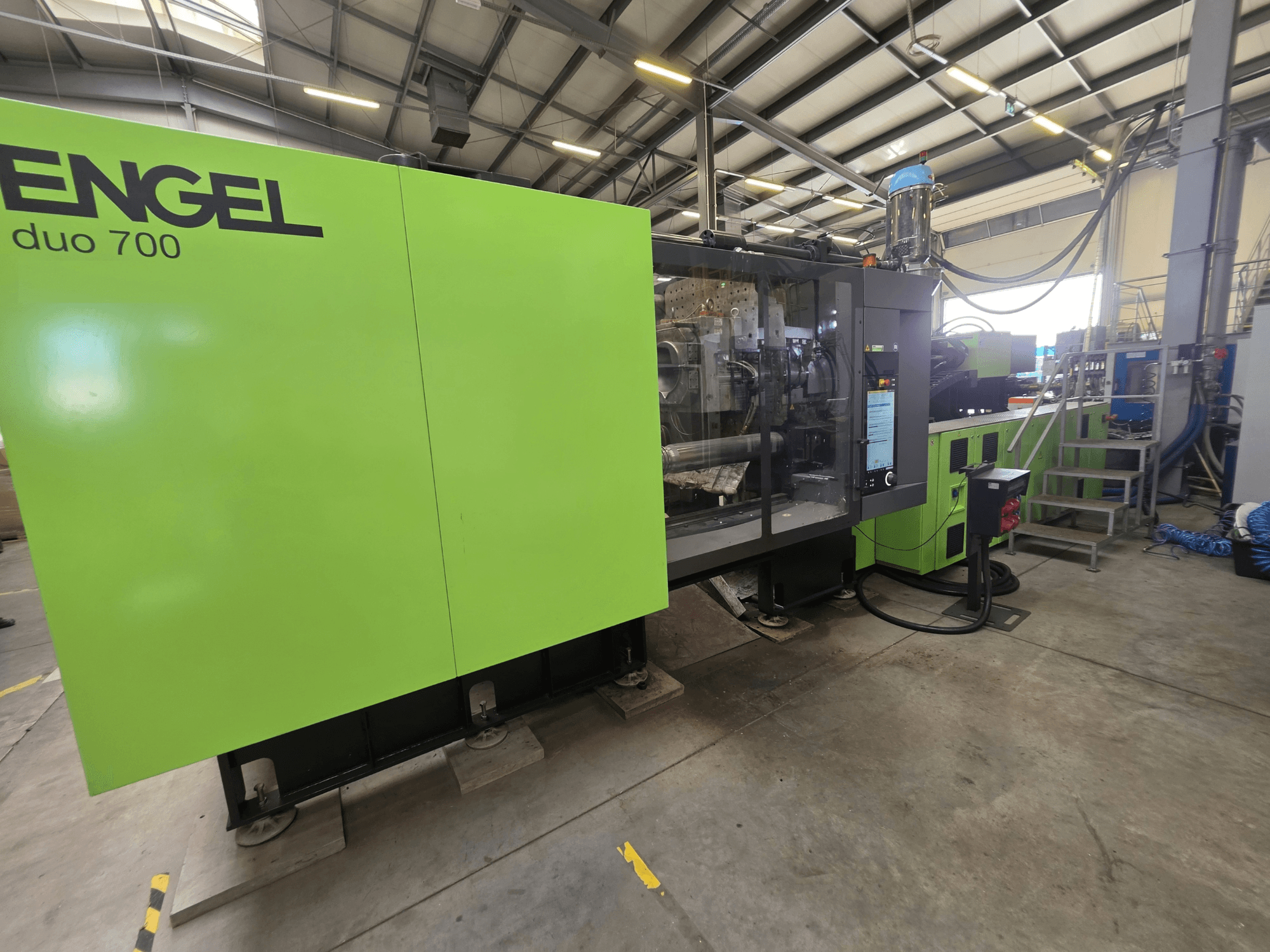 Macchina per stampaggio a iniezione idraulica Engel duo 700, vista frontale, con carrozzeria verde e pannello di controllo.