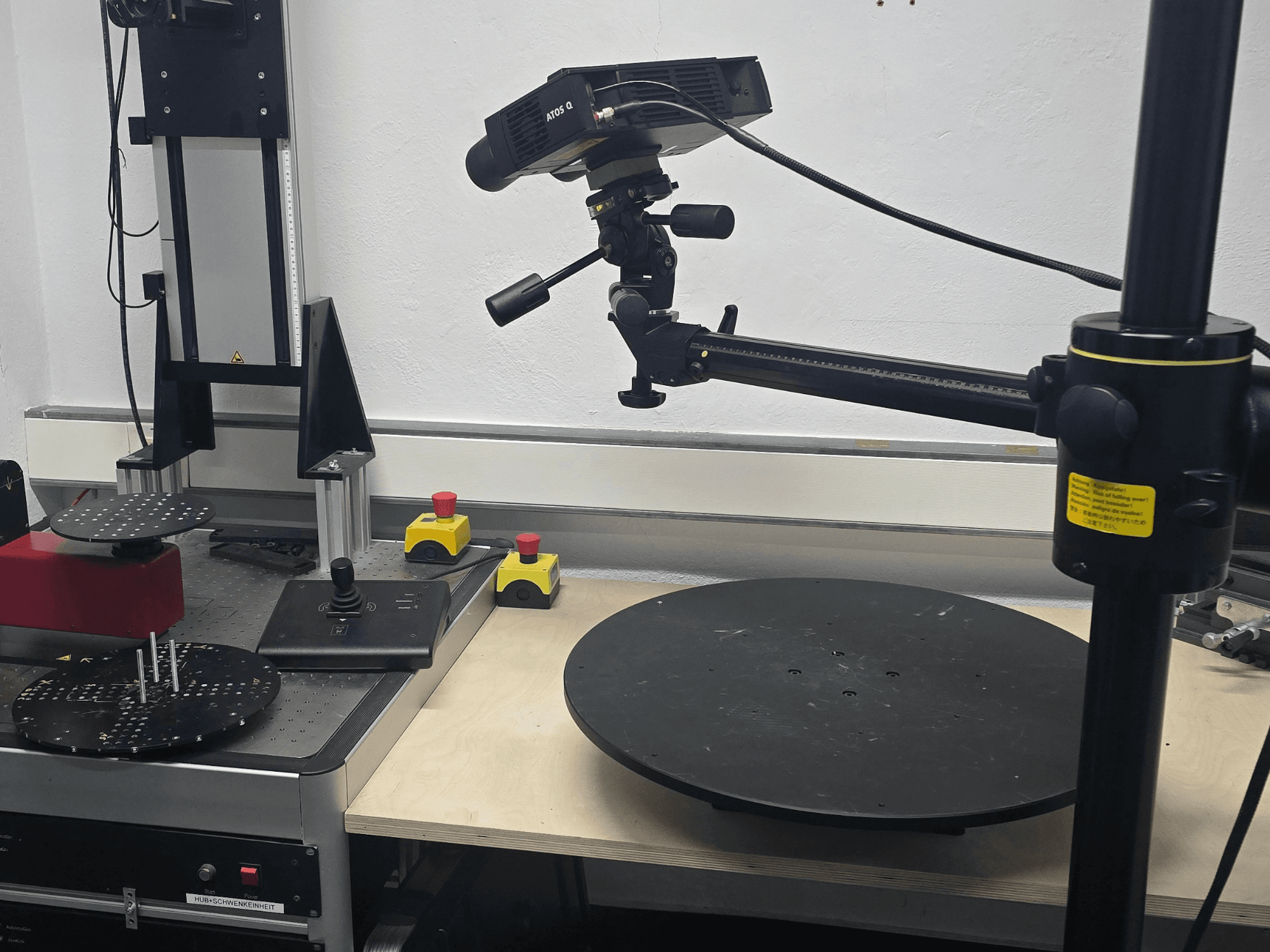 Vista frontale della macchina di misura ottica ZEISS ATOS Q 12M, dotata di testa di scansione, pannello di controllo e piattaforma circolare girevole.