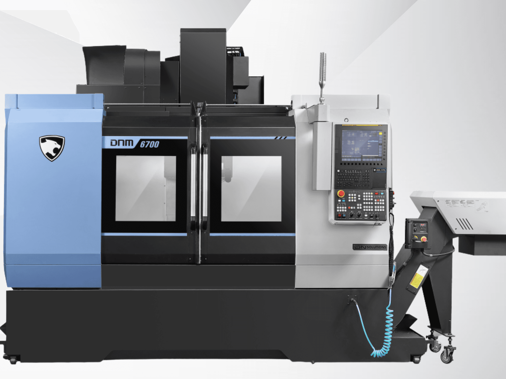 Centro di lavorazione verticale DN SOLUTIONS DNM 6700 visto frontalmente, con pannello di controllo e doppia porta in vetro.