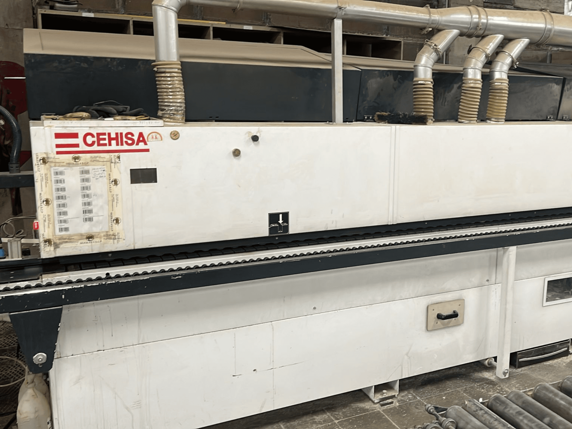 Bordatrice CEHISA PRO 12 CONCEPT vista frontale, con pannello di controllo, tubi di aspirazione della polvere e nastro trasportatore.
