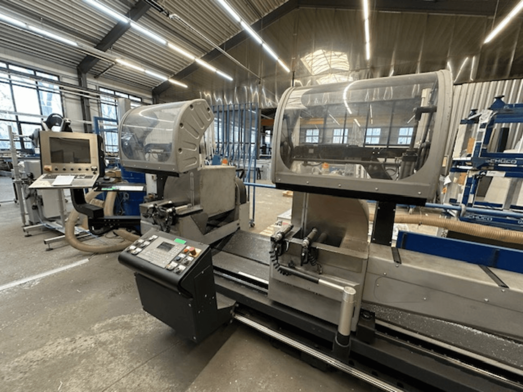 Sega circolare per metalli SCHÜCO PDG E CUT, vista frontale, con pannello di controllo, coperture di protezione e area di taglio in un'officina.