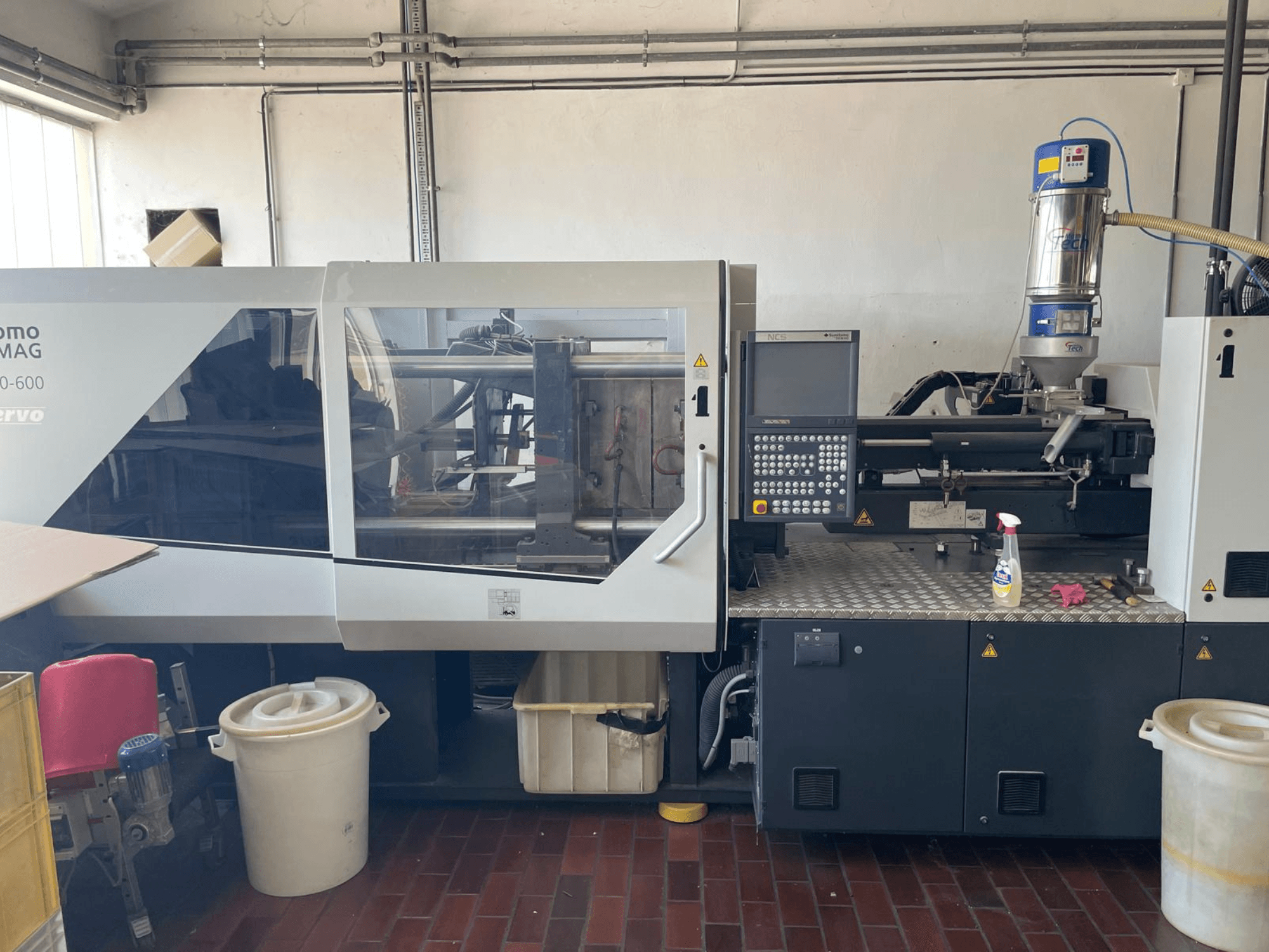 Vista frontale della pressa a iniezione idraulica SUMITOMO SHI DEMAG Systec 160/520-600 con pannello di controllo e unità di alimentazione.