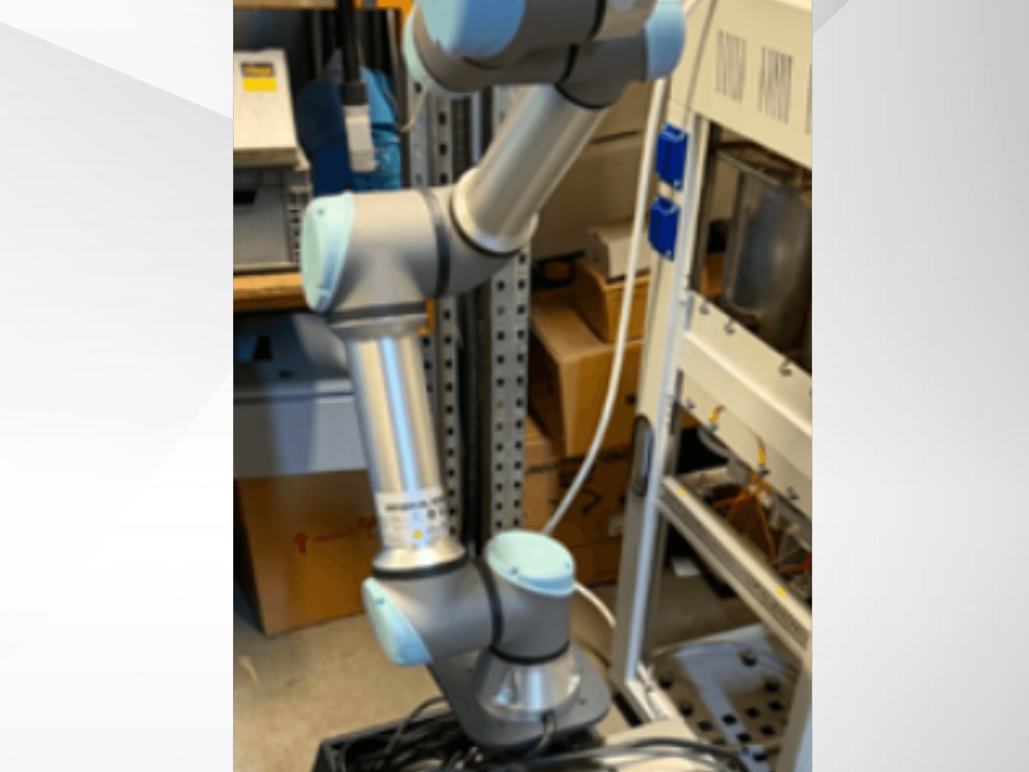 Braccio robotico UR5e di Universal Robots visto di lato, che mostra i giunti articolati, il design leggero e i cavi di controllo.