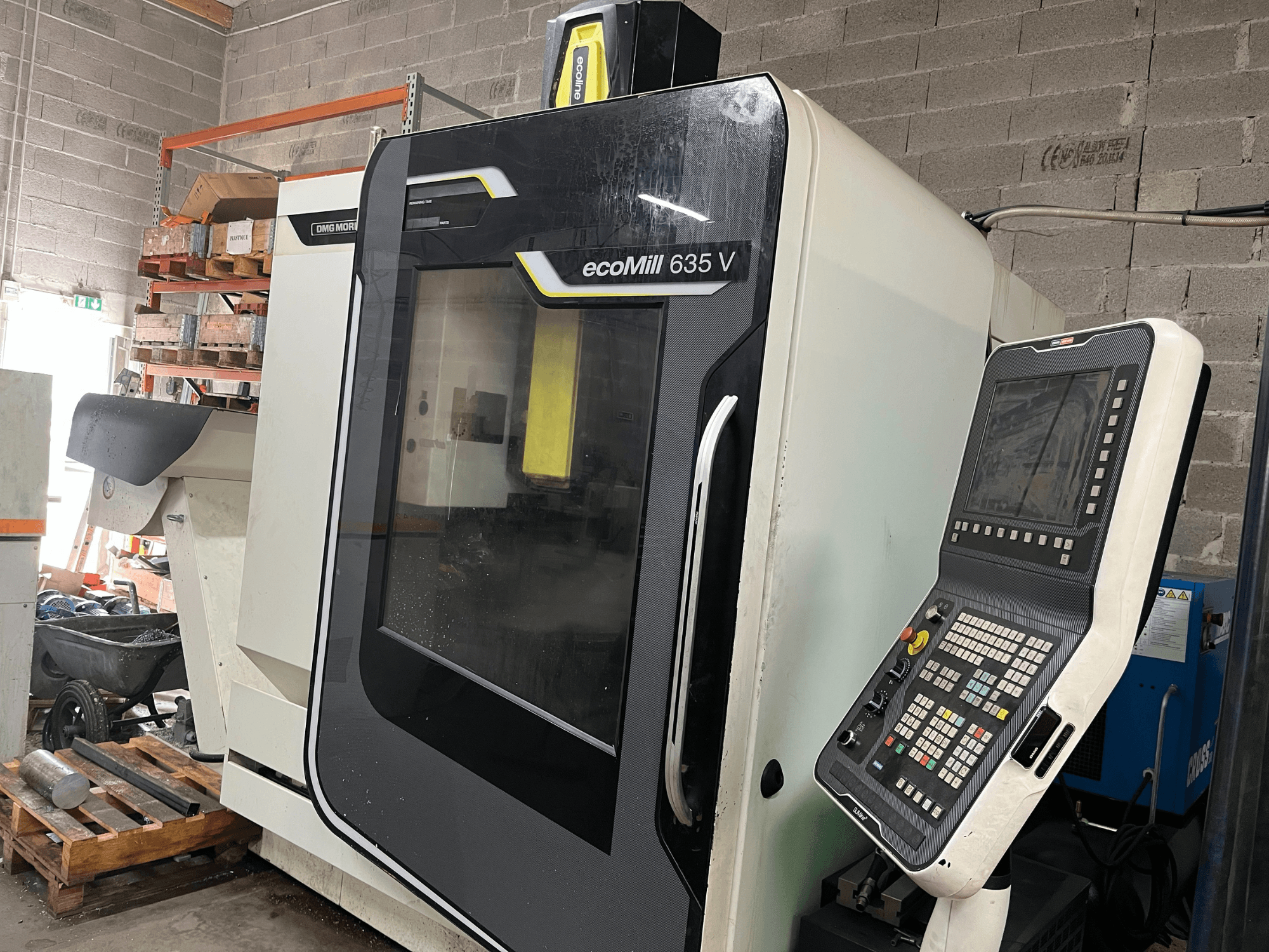 Fresatrice CNC EcoMill 635 V, vista frontale, pannello di controllo con pulsanti, situata in un'area di lavoro industriale.