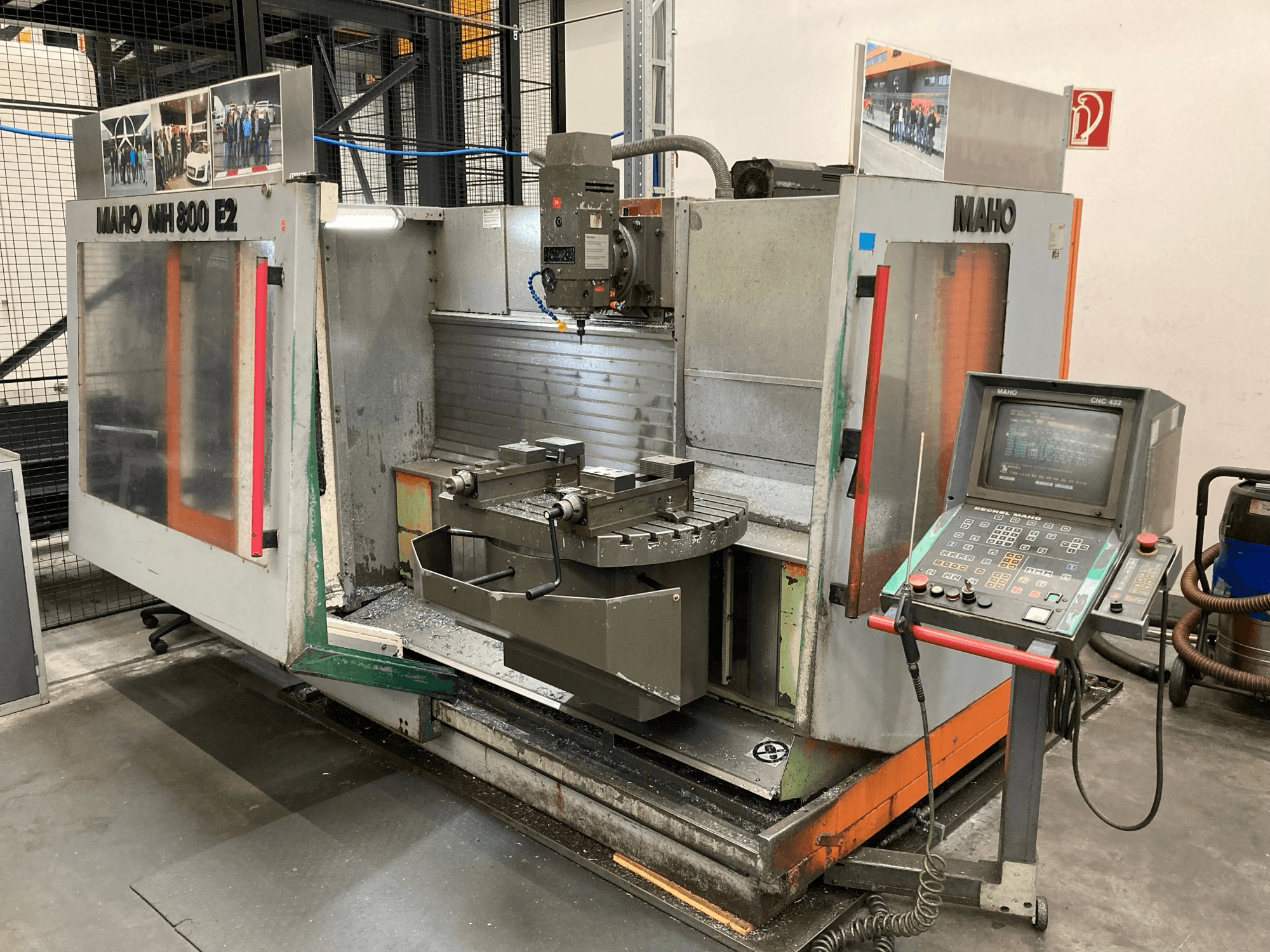 Fresatrice CNC Maho MH 800 E2 in vista frontale con pannello di controllo, mandrino e piano di lavoro visibili.