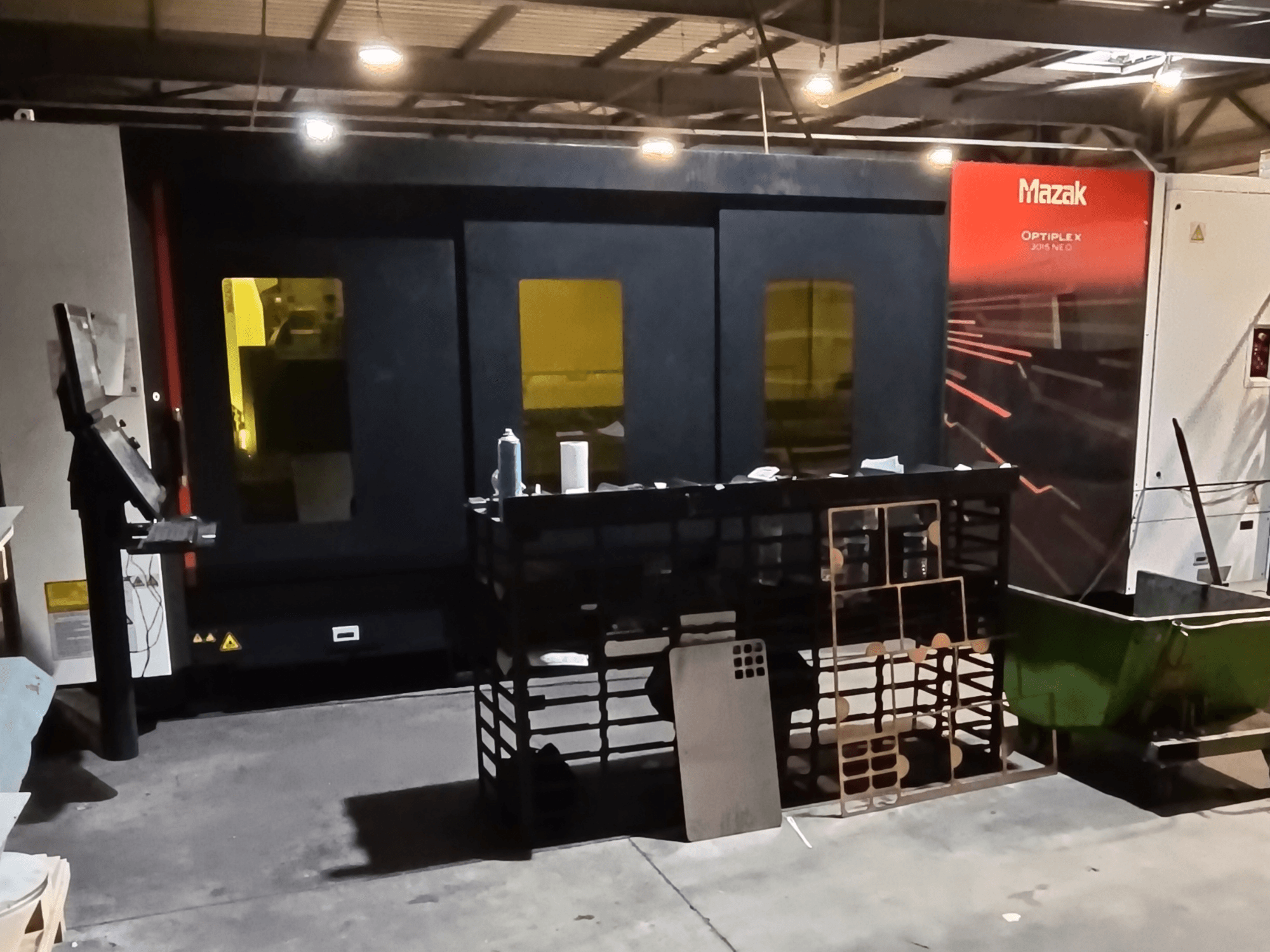 Macchina da taglio a laser a fibra Mazak OPTIPLEX NEO in un'officina, vista frontale con pannello di controllo e area di lavorazione visibili.