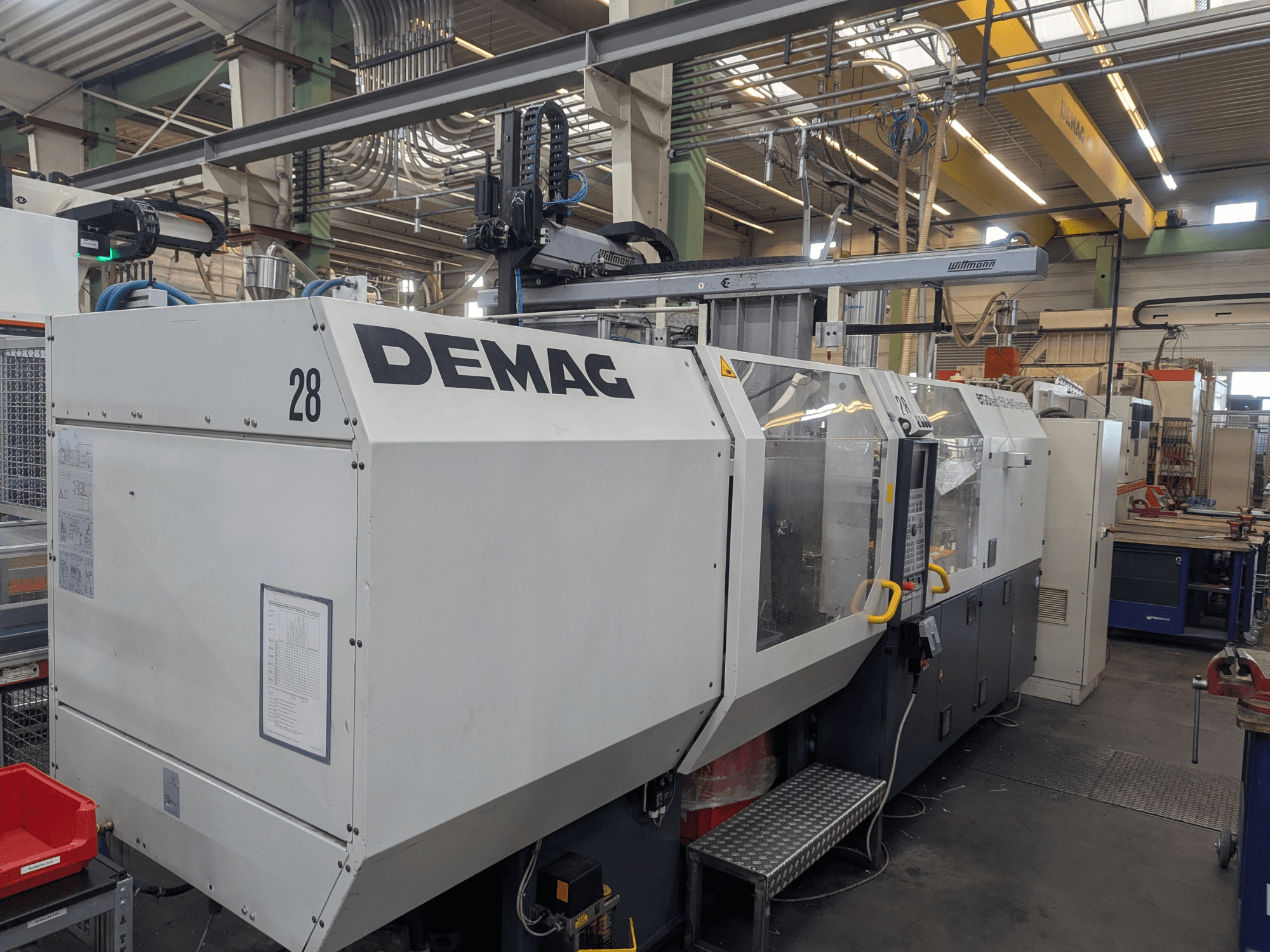 Vista frontale di una pressa a iniezione idraulica DEMAG ERGOTECH 1500-840, che mostra i comandi operativi e le caratteristiche di sicurezza.