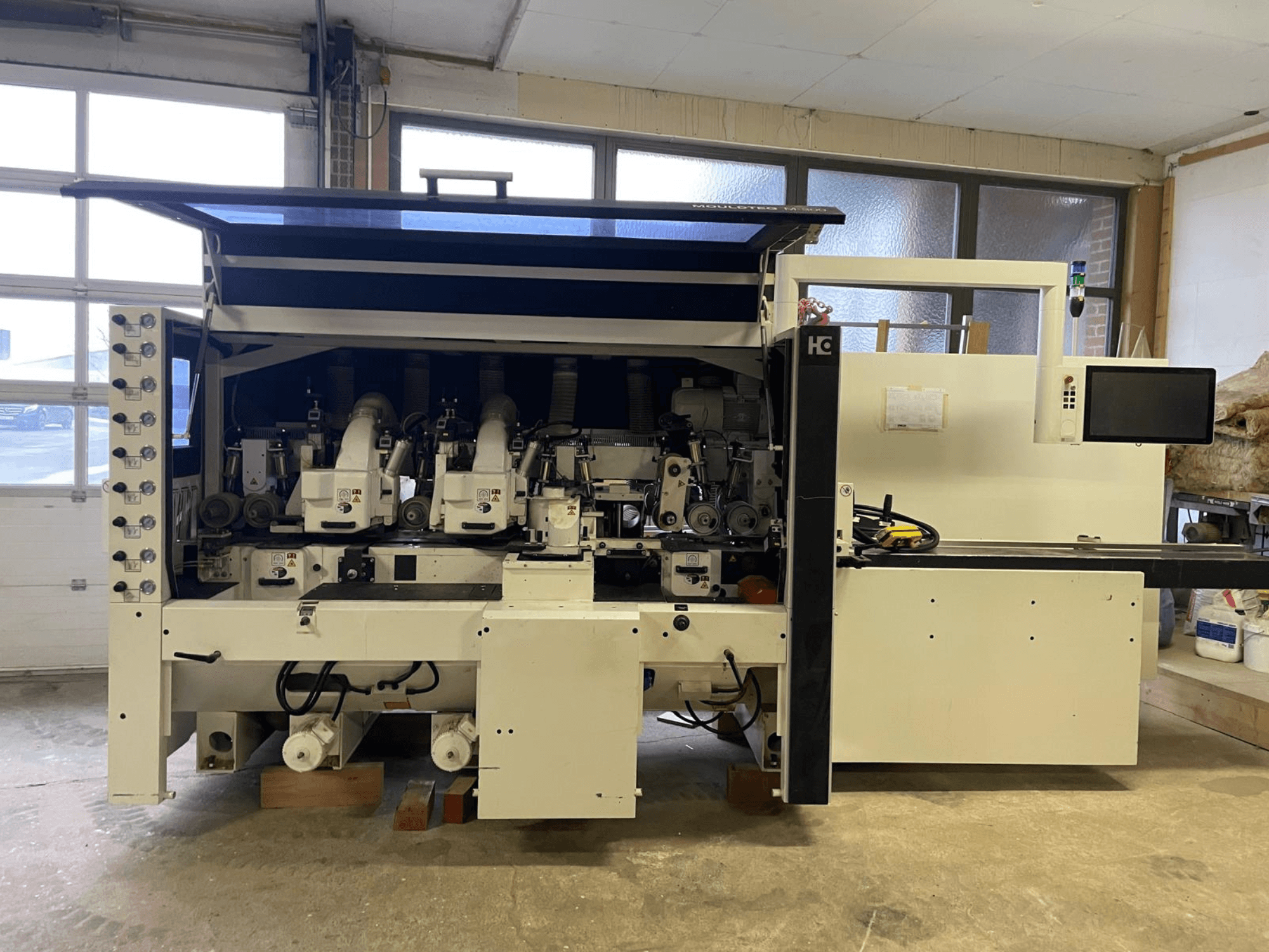 Macchina CNC Häwa, vista frontale, dotata di mandrini multipli, pannello di controllo e tubi di aspirazione della polvere, adatta alla lavorazione del legno.