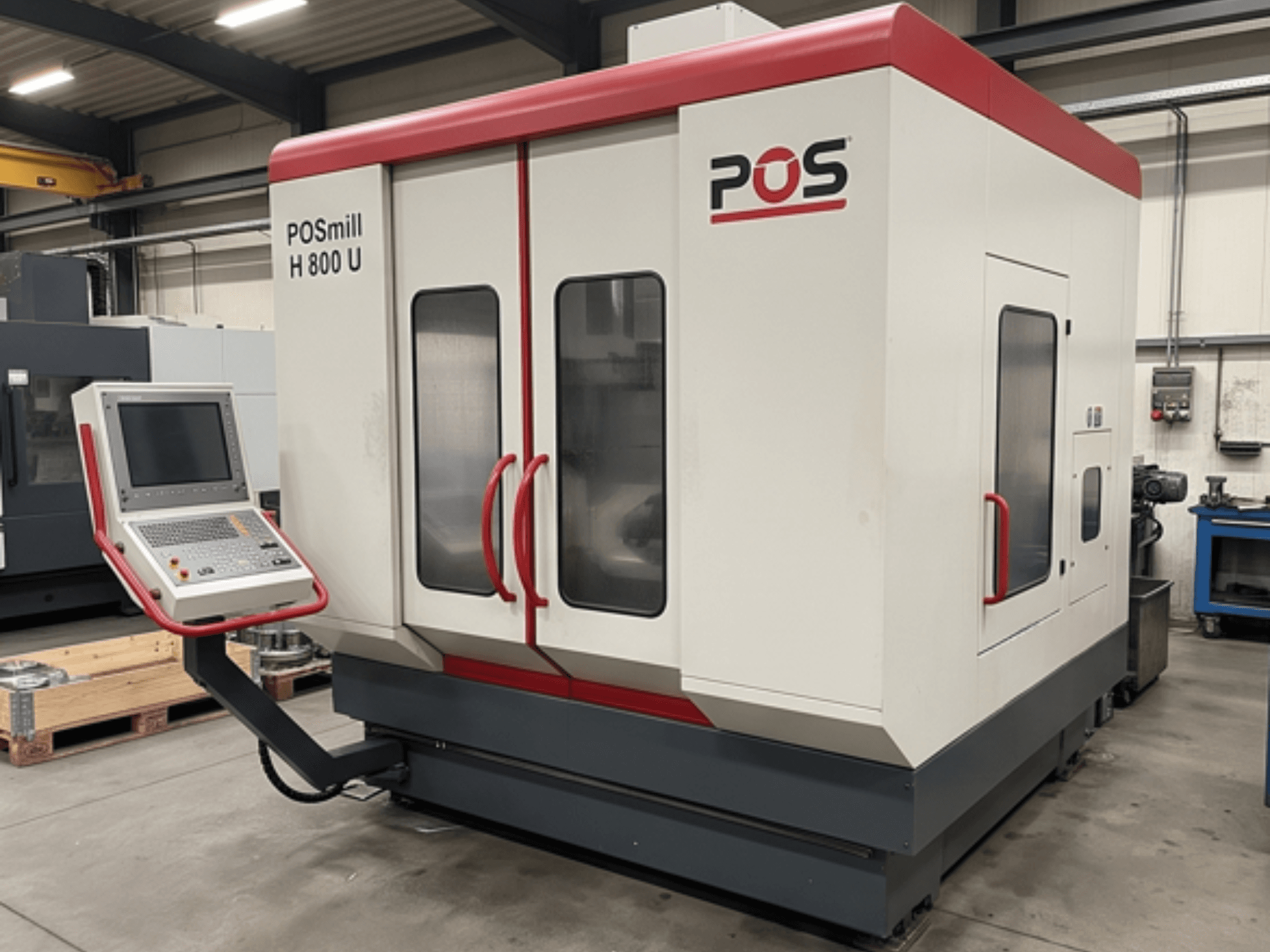 Centro di lavorazione verticale POSmill H800U in un'officina, dotato di pannello di controllo e doppia porta in vetro. Prospettiva laterale.