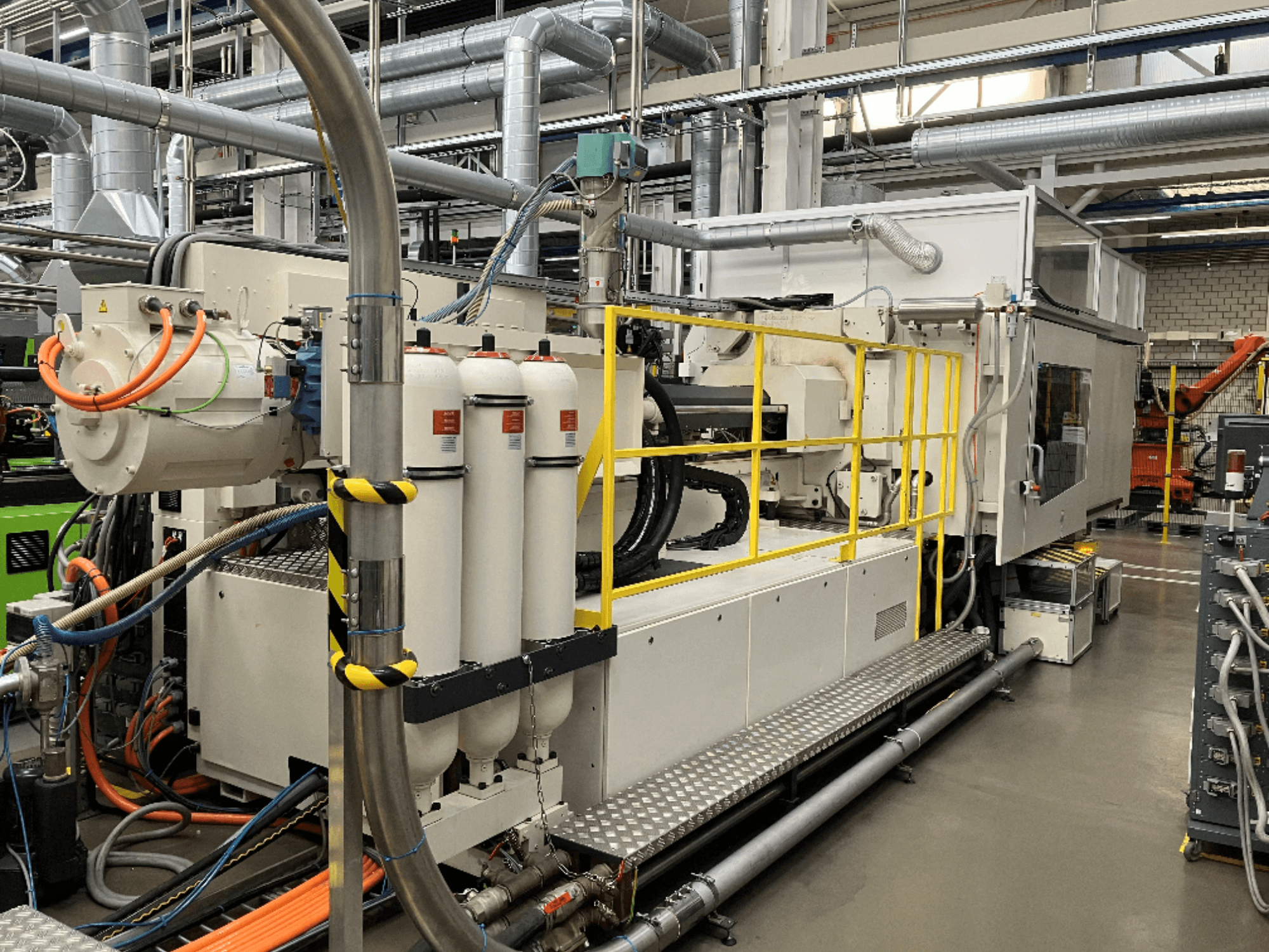 Macchina industriale con involucro bianco e grigio, tubi multipli e serbatoi filtranti; vista laterale che mostra la configurazione operativa.