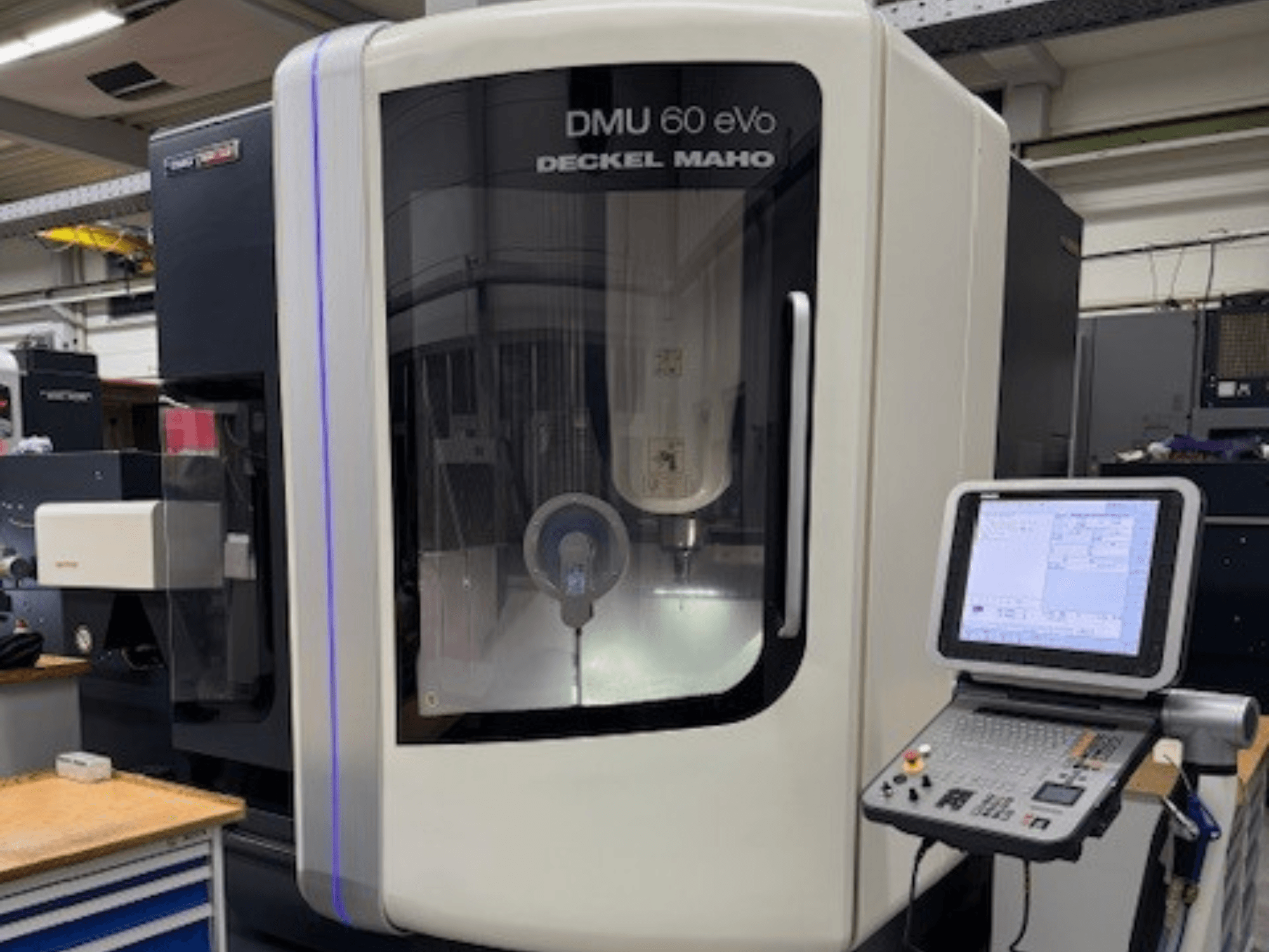 DMU 60 eVo di DECKEL MAHO, vista frontale della fresatrice a controllo numerico con pannello di controllo e display, con componenti di precisione.