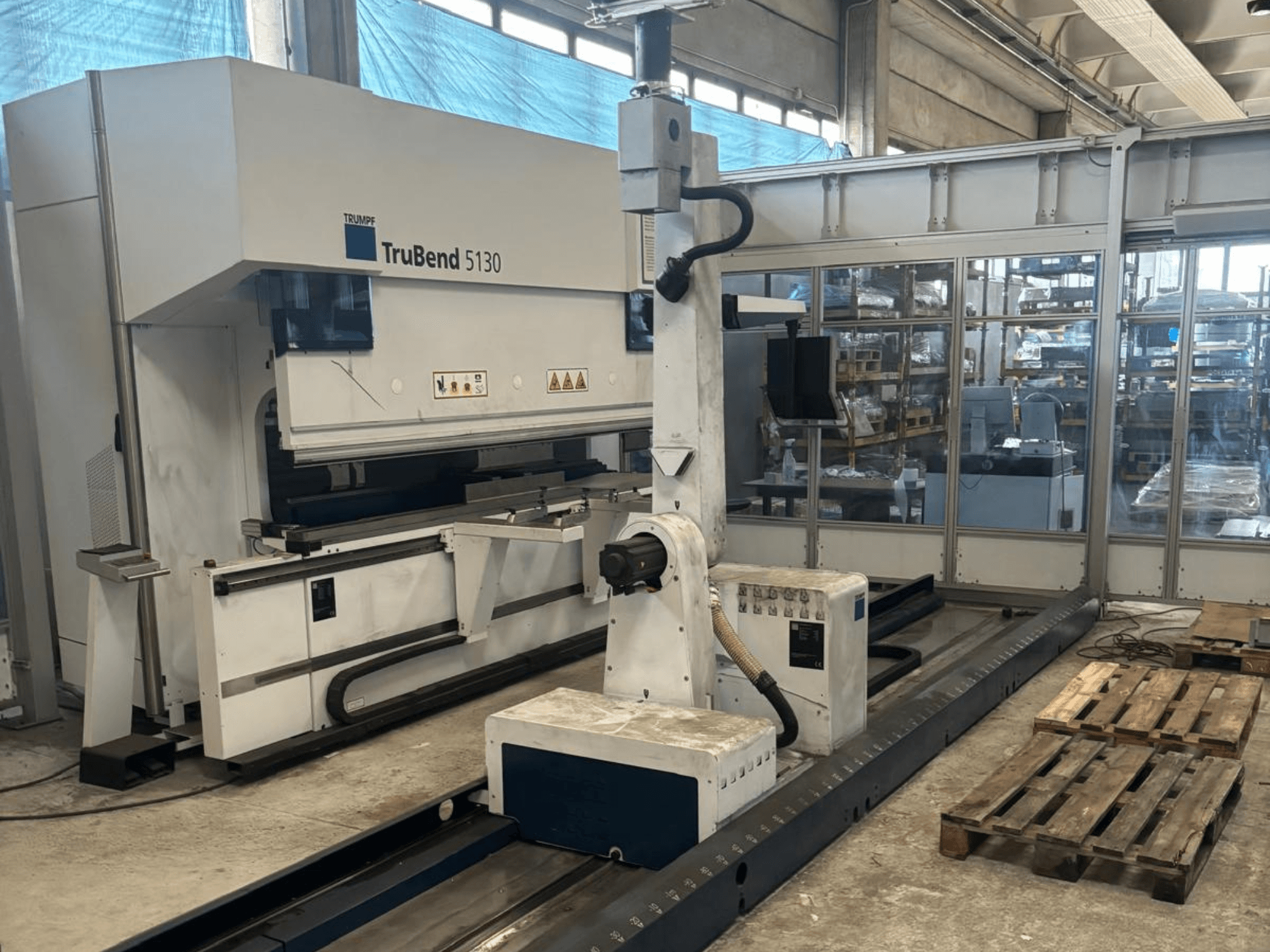 Curvatrice TruBend 5130 di Trumpf, vista frontale, con pannello di controllo e pallet in un ambiente di fabbrica.