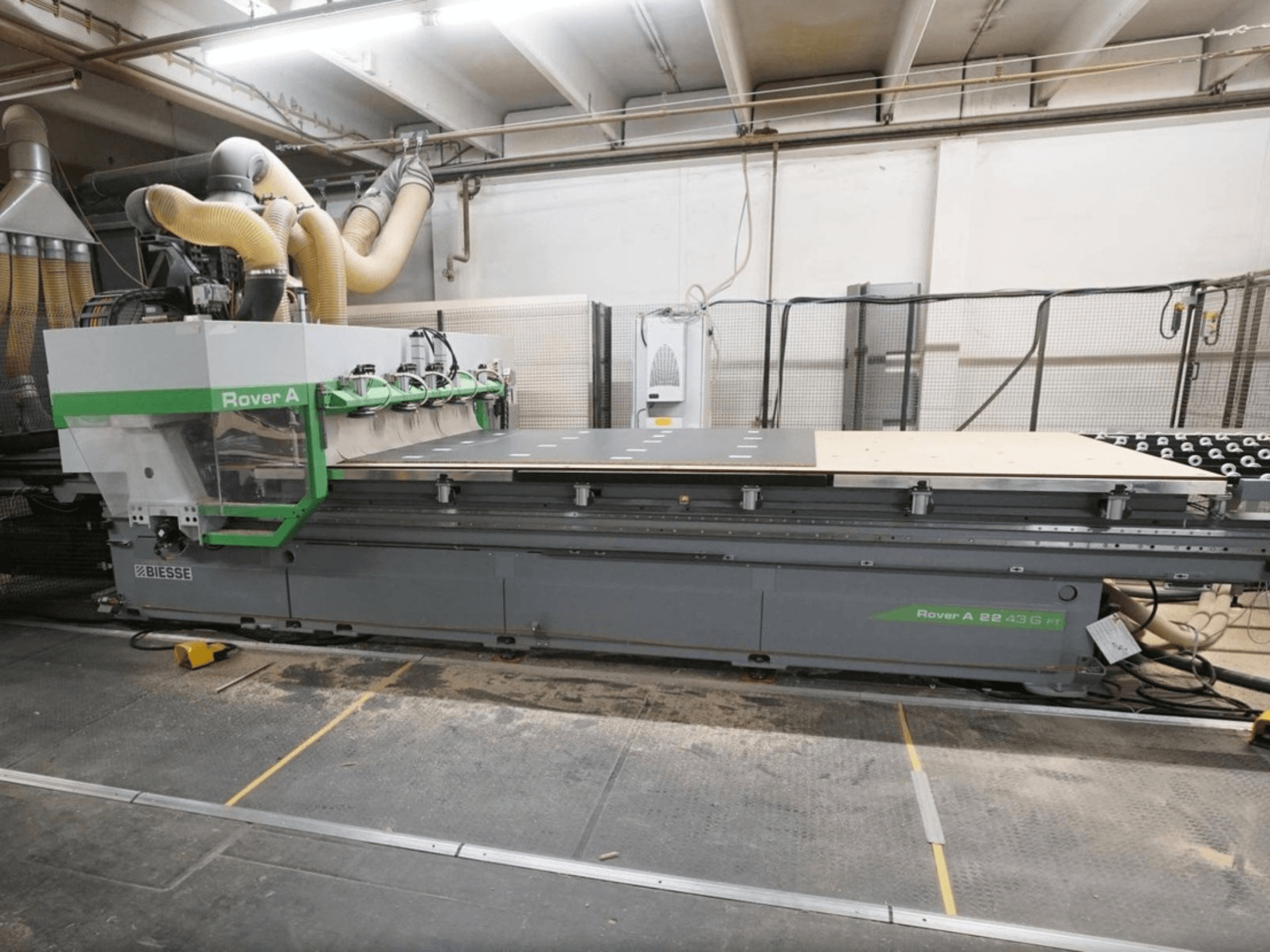Centro di lavorazione del legno a controllo numerico BIESSE Rover A FT 2243, vista frontale, dotato di un ampio piano di lavoro e di un sistema di fissaggio degli utensili.