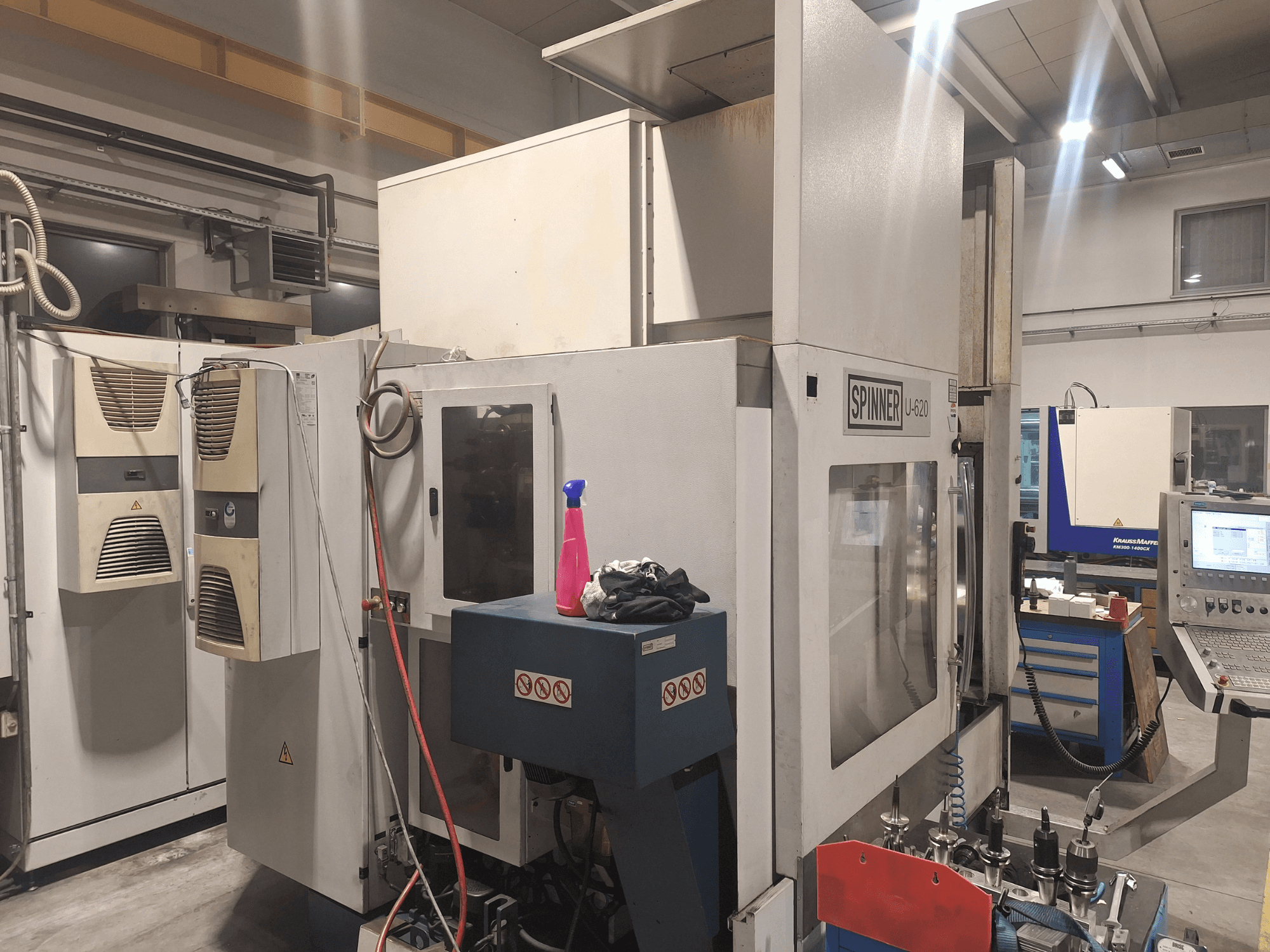 Macchina CNC Spinner U-620 vista frontalmente in un'officina, con pannello di controllo e vari utensili su un banco di lavoro vicino.