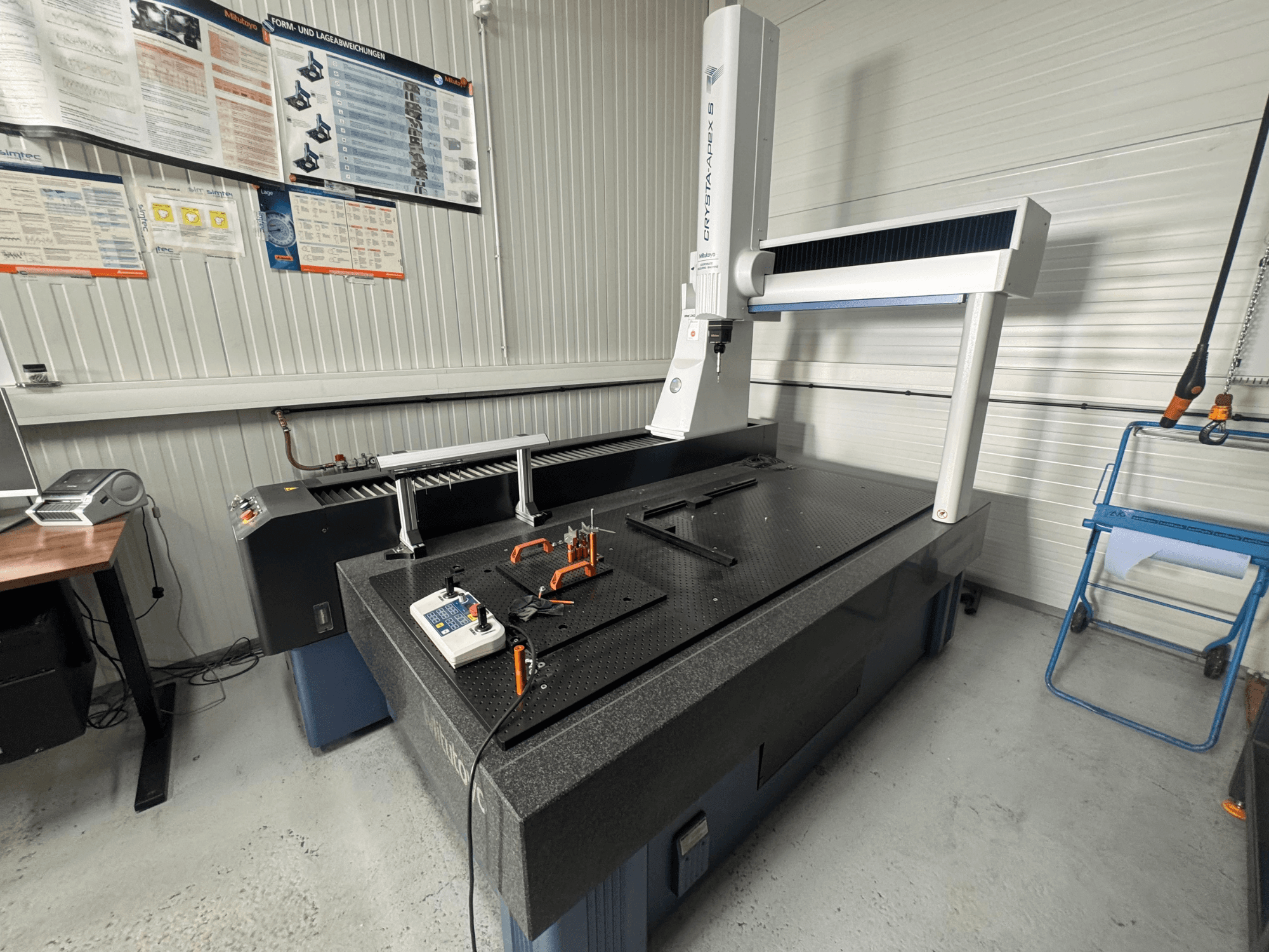 Macchina di misura a coordinate CMM del marchio Leitz, vista frontale su una superficie nera strutturata con strumenti di misura.