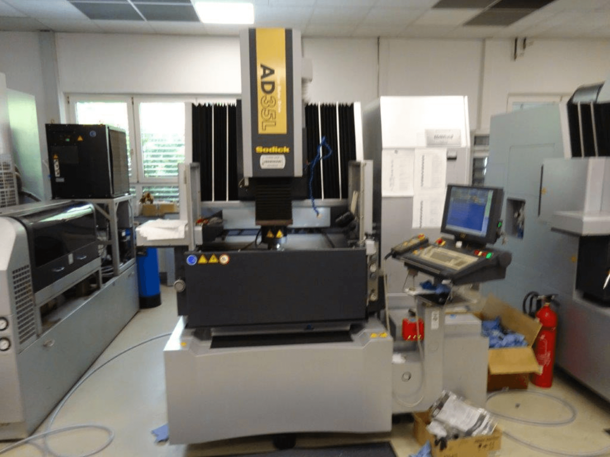 Macchina CNC Sodick AD35L vista frontalmente, con pannello di controllo, unità di raffreddamento e indicatori di sicurezza.