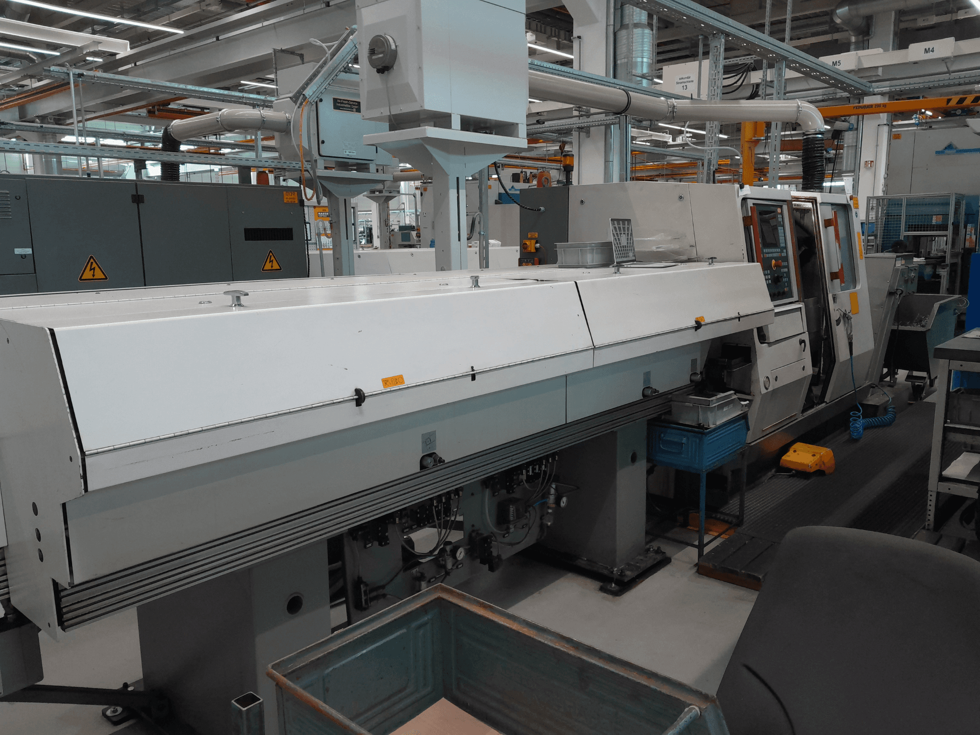 Tornio orizzontale TRAUB TNA 300, vista frontale; presenta un design elegante, un pannello di controllo e uno spazio di lavoro operativo.